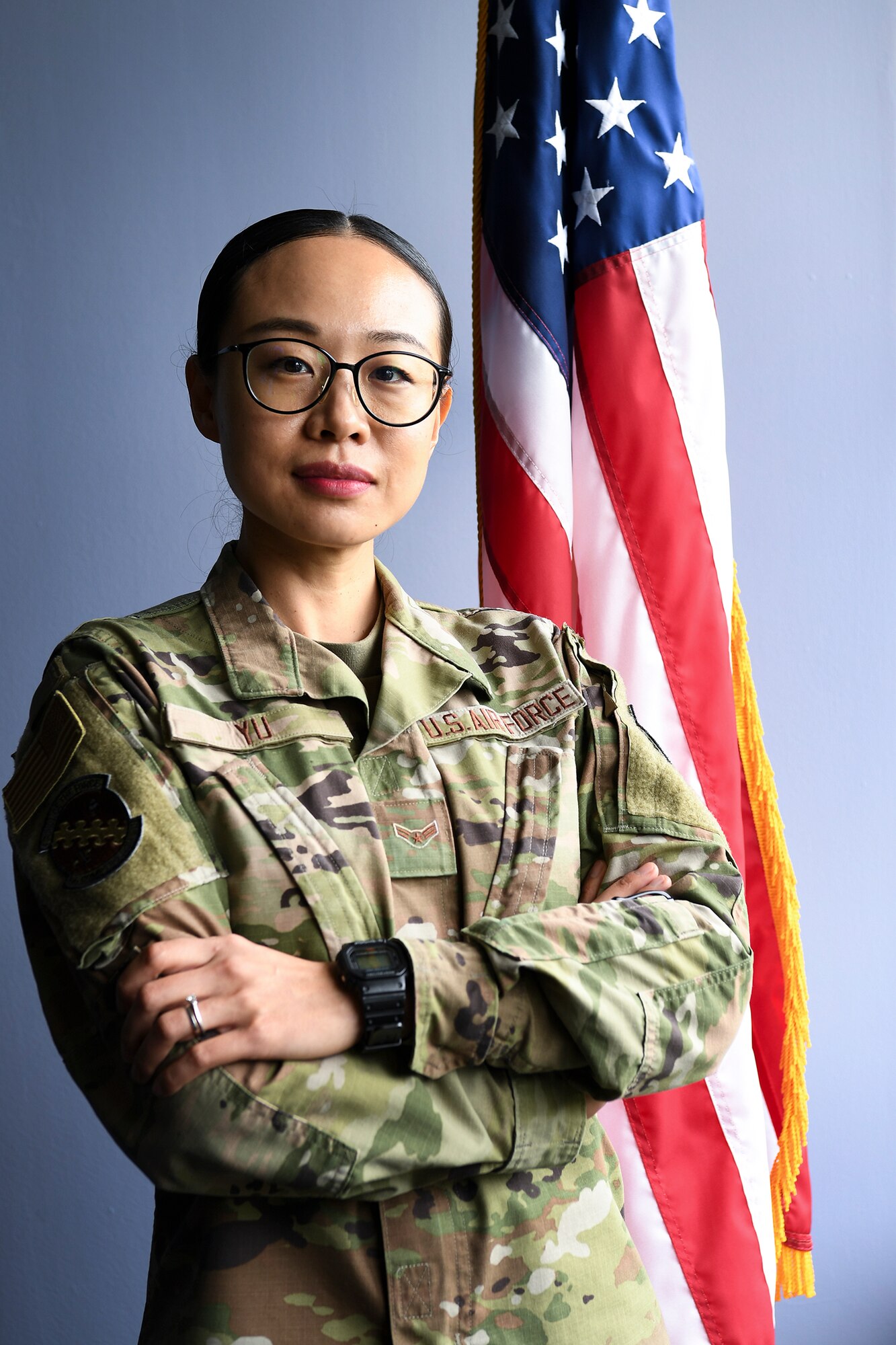 Airman 1st Class Ling Yu, 66th Comptroller Squadron financial accounting technician, stands by a flag in the 66 CPTS conference room at Hanscom Air Force Base, Mass., Aug. 10. Yu received her U.S. citizenship July 23. (U.S. Air Force photo by Lauren Russell)