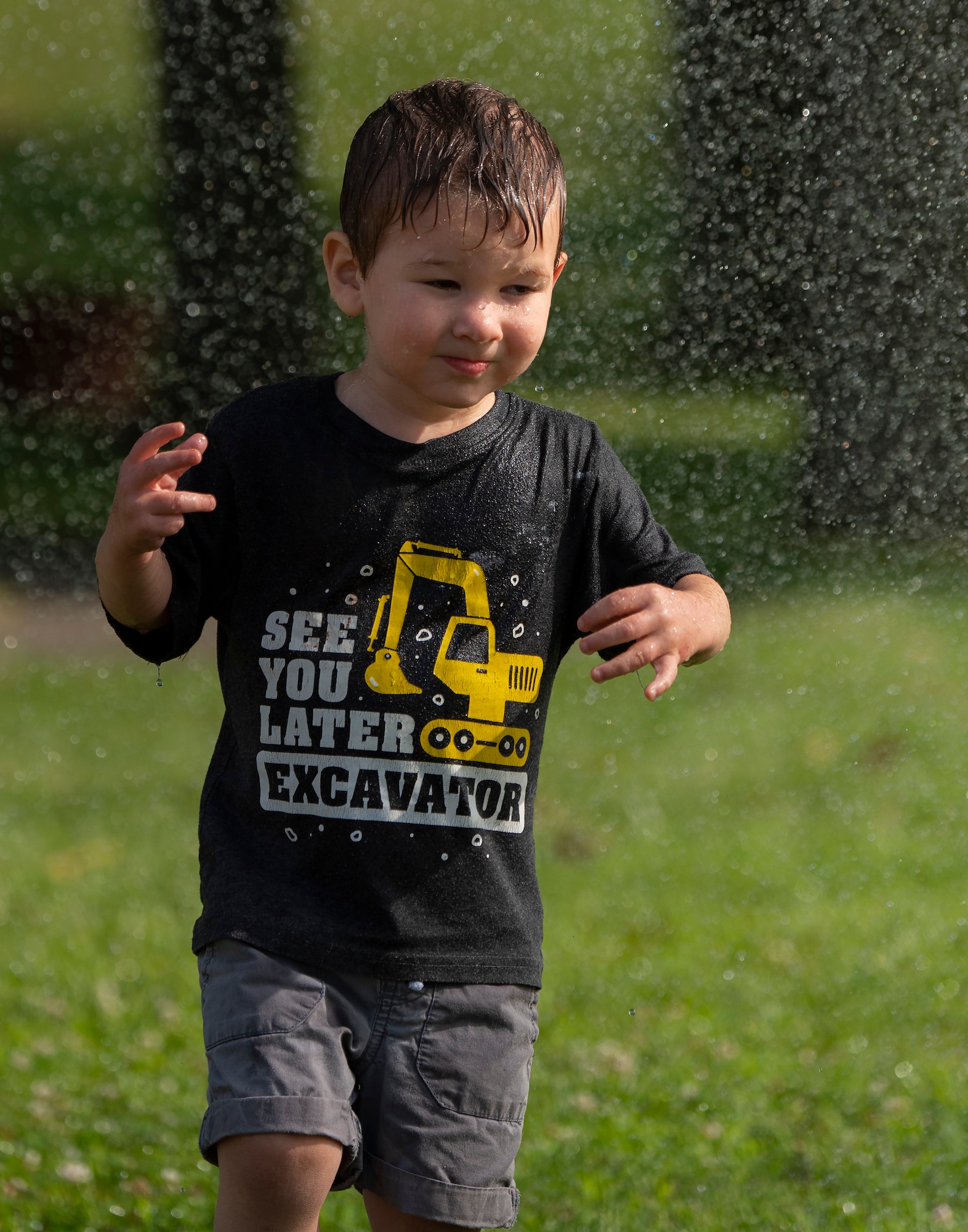 Child plays in the spray of a fire hose during National Night Out at Wright-Patterson Air Force Base.
