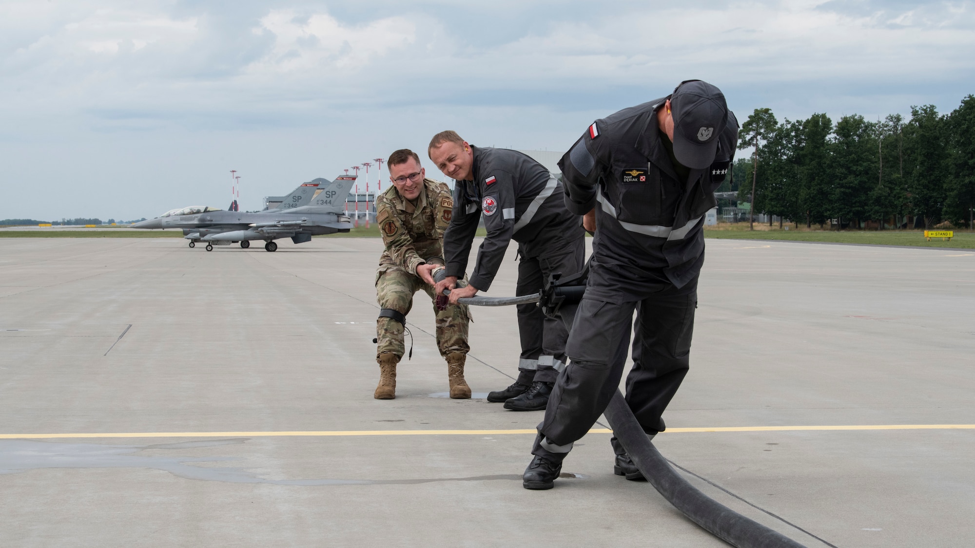 U.S. Air Force Master Sgt. Jason Yunker, 480th Expeditionary Fighter Squadron Fuels Management Flight operations superintendent (left), guides members of the Polish air force through a Versatile Integrating Partner Equipment Refueling Kit (VIPER) kit demonstration at Powidz Air Base, Poland, Aug. 10, 2021. U.S. Air Force Airmen from the 126th Air Refueling Wing at Scott Air Force Base, Ill., who are participating in the ADR, were also present during the demonstration and had the opportunity to both ask questions and test out the kit. (U.S. Air Force photo by Tech. Sgt. Anthony Plyler)