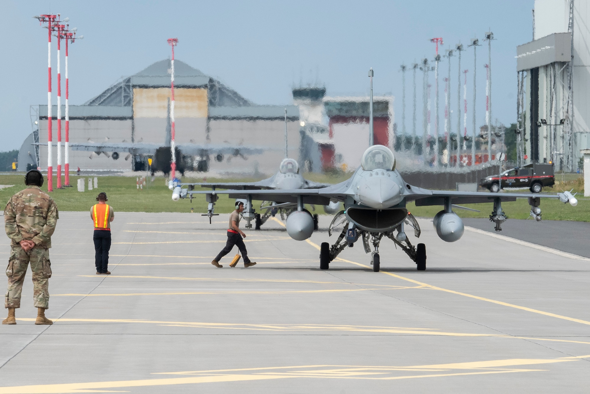U.S. Air Force Airmen from the 480th Expeditionary Fighter Squadron receive two U.S. Air Force F-16 Fighting Falcon fighter jets at Powidz Air Base, Poland, Aug. 10, 2021. The Airmen incorporated Agile Combat Employment concepts by transporting a small contingency of Airmen from Łask Air Base, Poland, specifically to test the hot pit refueling capabilities of the Versatile Integrating Partner Equipment Refueling Kit (VIPER) kit. (U.S. Air Force photo by Tech. Sgt. Anthony Plyler)