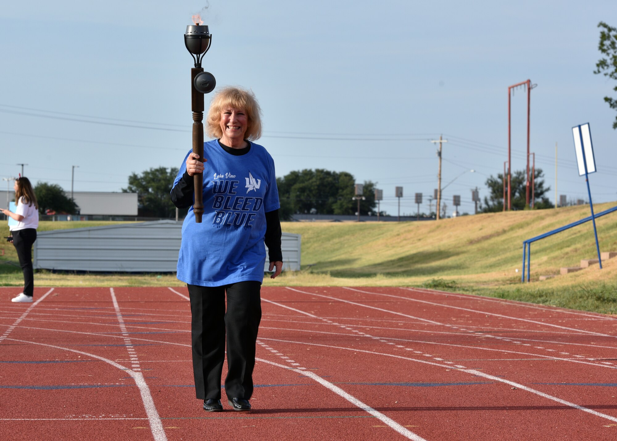 Team captain of Lake View High School, Laura Elms, carries the torch during the Olympiad at the San Angelo Independent School District Convocation at San Angelo Stadium in San Angelo, Texas, August 11, 2021. Elms kicked off the event in a fashion similar to the Olympic games. (U.S. Air Force photo by Senior Airman Ashley Thrash)
