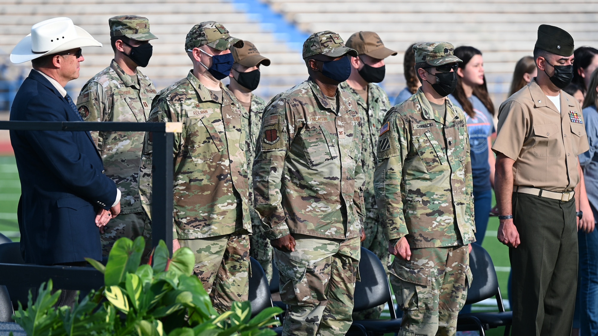 Goodfellow Air Force Base leadership stands at attention for the singing of the Armed Forces Medley by the choir during the San Angelo Independent School District Convocation at San Angelo Stadium in San Angelo, Texas, August 11, 2021. SAISD schools provided a choir, marching band, mariachis, and orchestra for the event. (U.S. Air Force photo by Senior Airman Ethan Sherwood)
