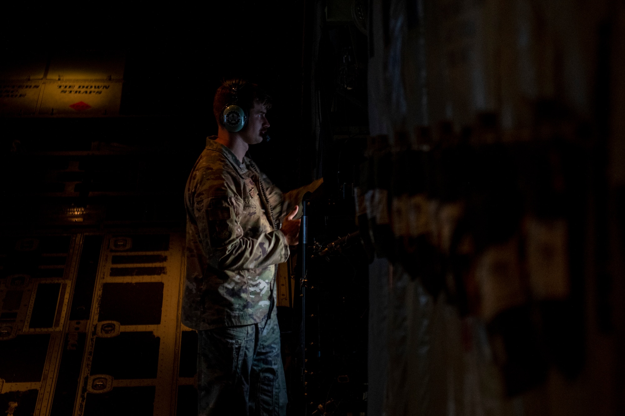 U.S. Air Force Tech. Sgt. John Richman, a 492nd Special Operations Training Group Detachment 2 loadmaster, scans the airfield in a modified EC-130J Commando Solo during Operation Blood Rain near Eglin Range, Florida, Aug. 5, 2021.