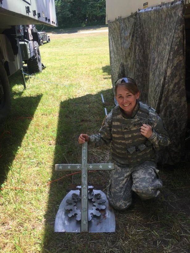Sgt. Bobbie Goss, FMC, 149th BSB, poses with the HHC guidon stand she fabricated in 2014