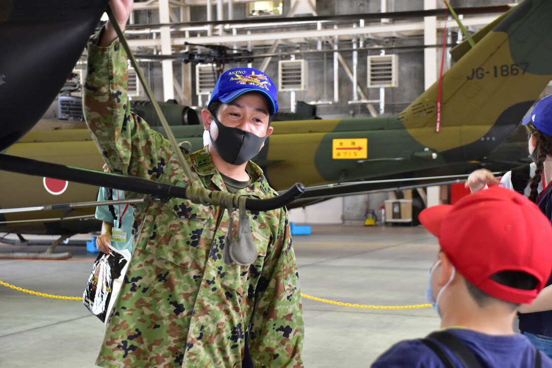 A Japan Ground Self-Defense Force soldier teaches local children and volunteers about JGSDF air capabilities, Aug. 7, 2021, Shizuoka, Japan. Marines and Sailors from Combined Arms Training Center Camp Fuji volunteered at the National Chuo Youth Friendship Center’s fifth annual English camp, where they engaged local children in conversation and activities. (U.S. Marine Corps photo by Katie Gray)