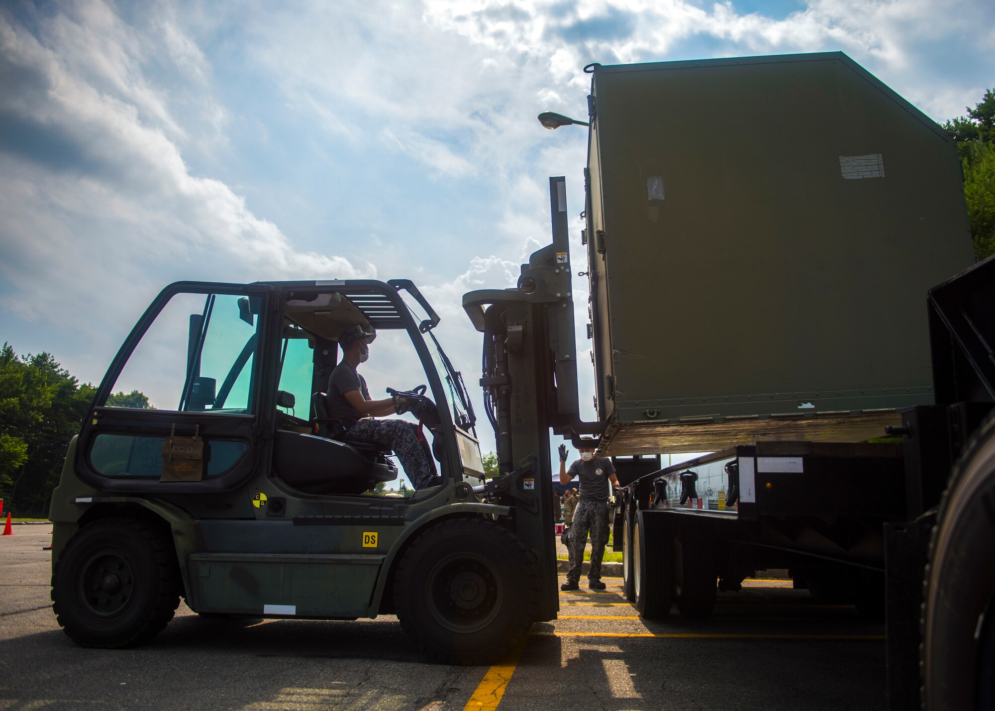 JASDF members operate a forklift to lift cargo onto truck.