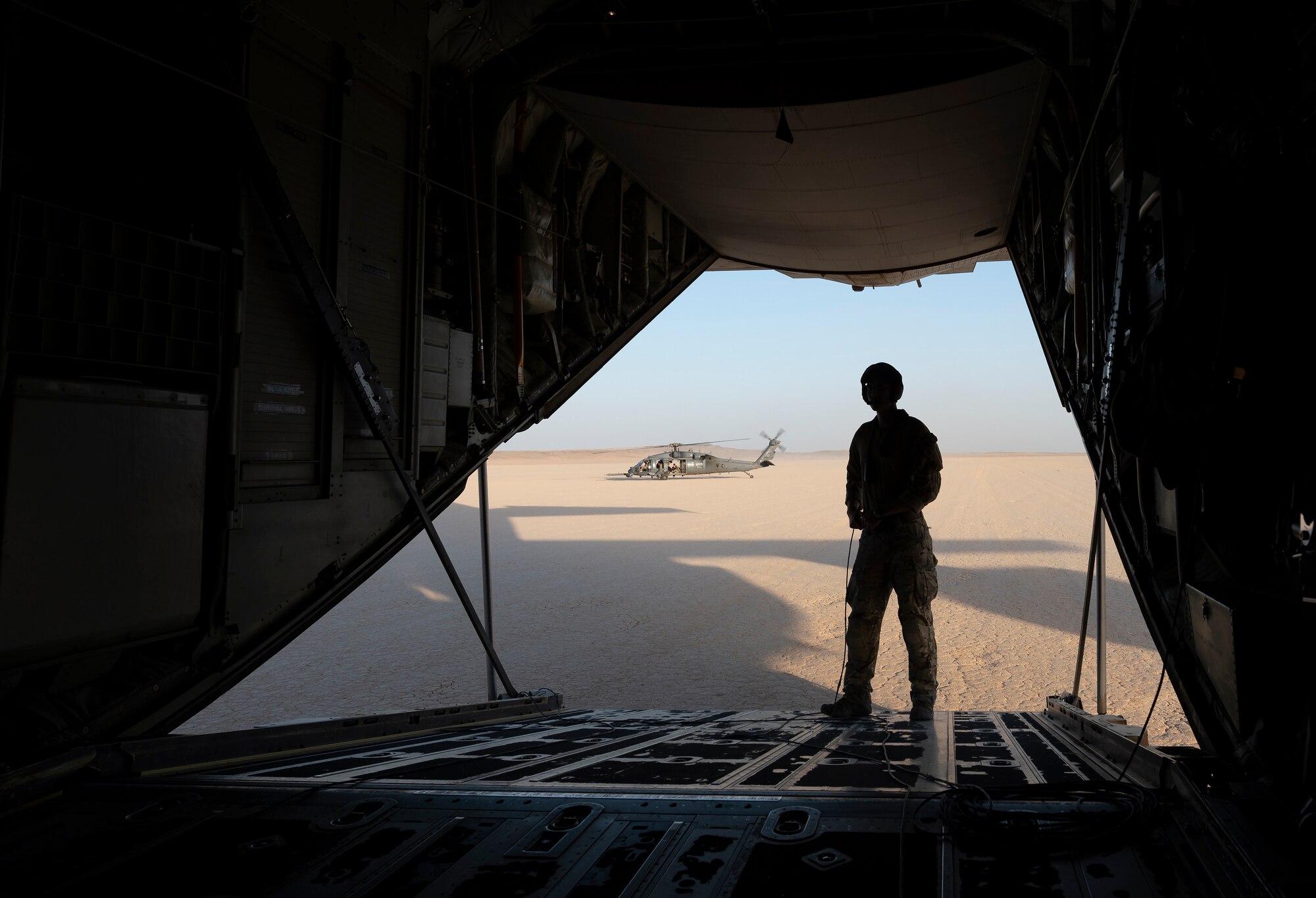 A U.S. Airman from the 26th Expeditionary Rescue Squadron stands on the ramp of a HC-130J Combat King II during an exercise July 28, 2021, at an undisclosed location somewhere in Southwest Asia. The 26th ERQS stands alert for the U.S. Central Command area of responsibility, providing tanker capability for the associated HH-60G Pave Hawk helicopters and can also provide a forward refueling point in austere locations. (U.S. Air Force photo by Senior Airman Karla Parra) (This image is blurred for security reasons)