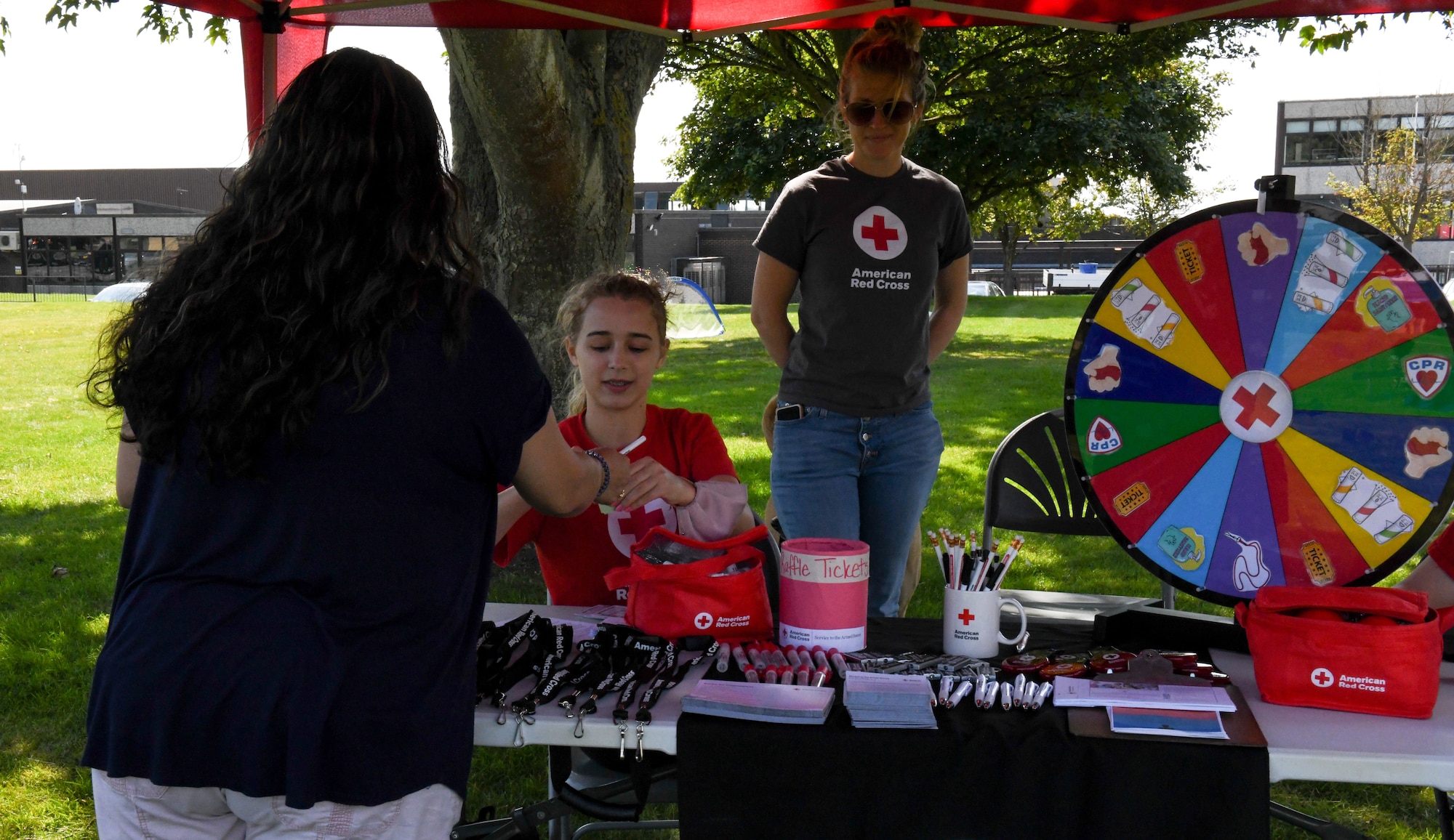 423d Air Base Group community members educate visitors on how the American Red Cross services and benefits military and civilian members at the “End of Lockdown” block party at Royal Air Force Alconbury, England, Aug. 11, 2021. Members from across the 501st CSW came out to support the various helping agencies on base. (U.S. Air Force photo by Senior Airman Gabrielle Winn)