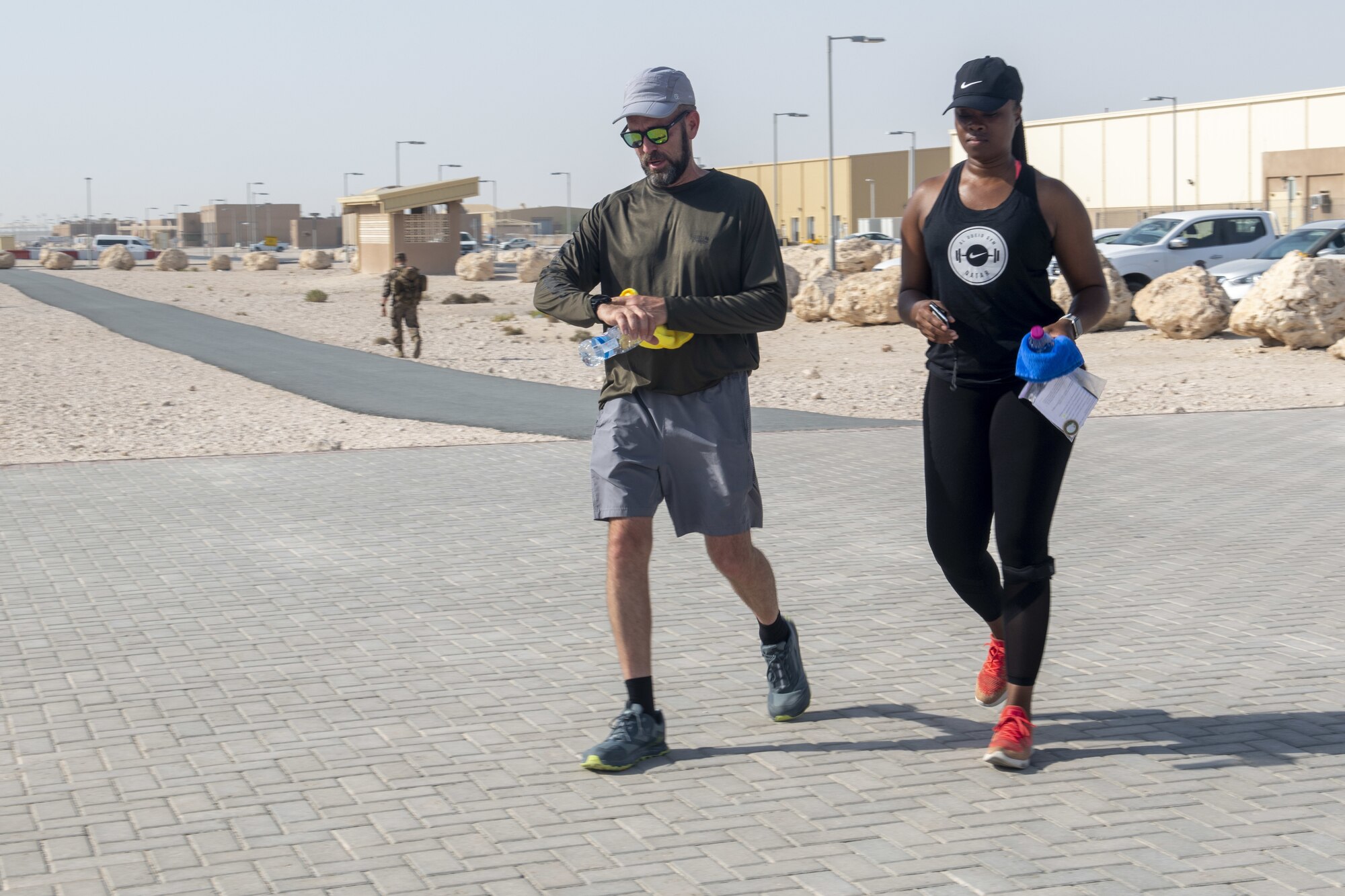 Chief Master Sgt. Tiwanda Wilson, AFCENT/A1 Forward superintendent, left, and Patrick Buzzard, AFCENT Information Protection director, right, jog during Buzzard’s 51-mile run at Al Udeid Air Base, Qatar, July 30, 2021. Buzzard ran 51 miles for his 51st birthday with the help of 13 members from the Combined Air Operations Center. (U.S. Air Force photo by Tech. Sgt. Dylan Nuckolls)