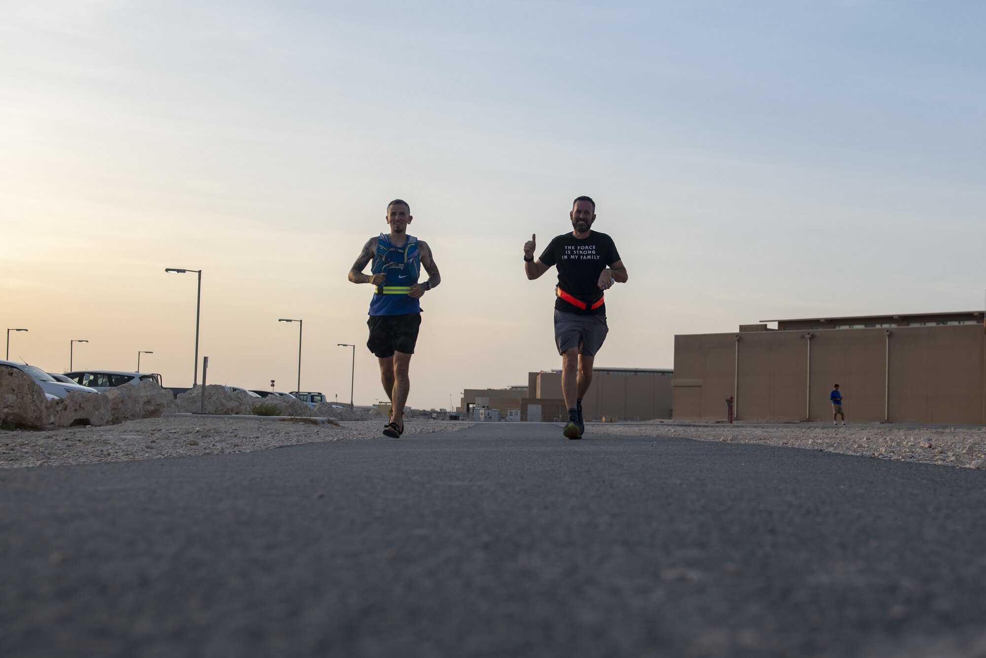 German Air Force Master Sgt. Christoph Lenz, Combined Air Operations Center German Detachment IT admin, left, and Patrick Buzzard, AFCENT Information Protection director, right, jog during Buzzard’s 51-mile run at Al Udeid Air Base, Qatar, July 30, 2021. Buzzard ran 51 miles for his 51st birthday with the help of 13 members from the CAOC. (U.S. Air Force photo by Tech. Sgt. Dylan Nuckolls)