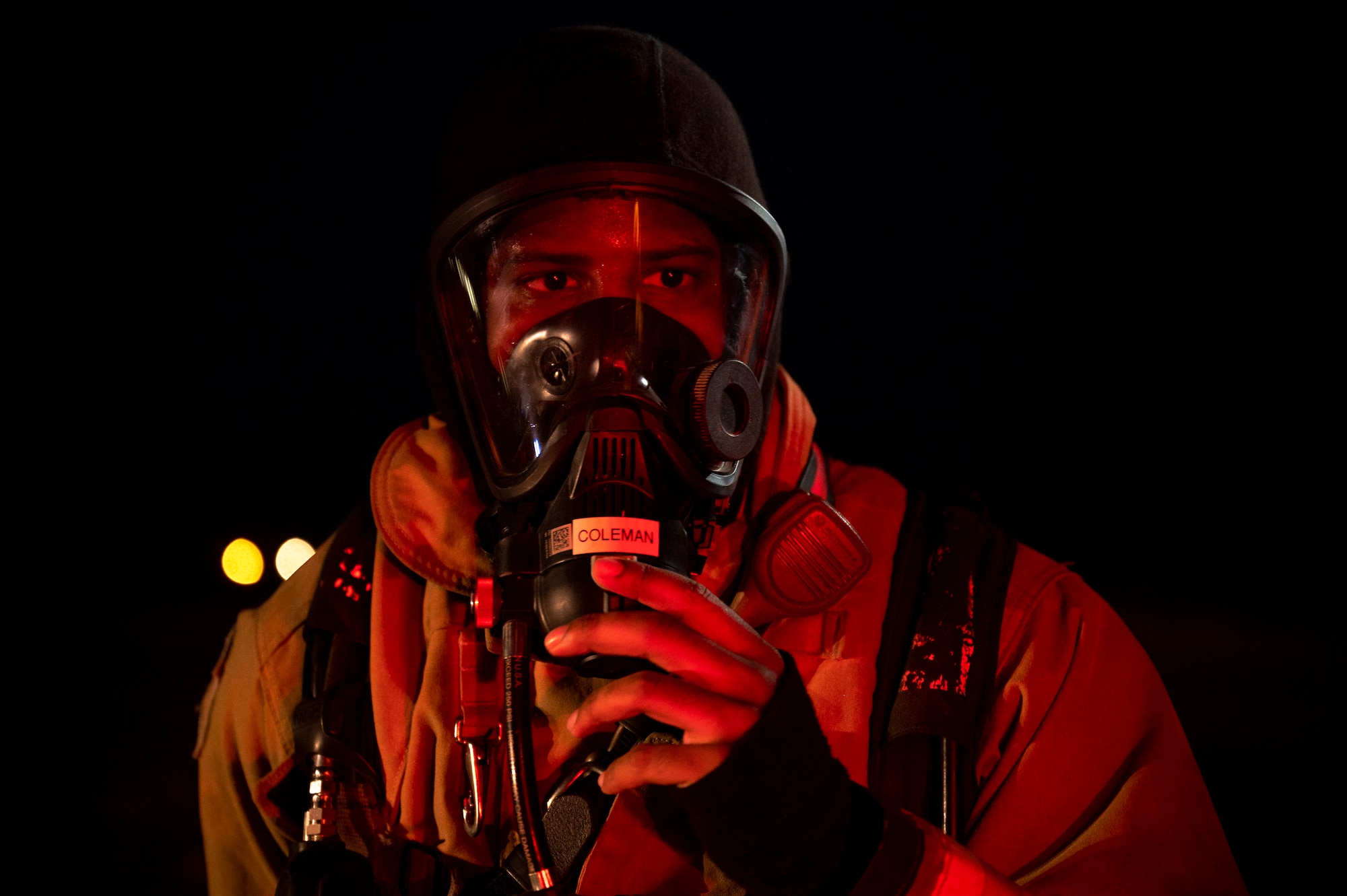 Airman 1st Class Javon Coleman, 379th Expeditionary Civil Engineer Squadron firefighter, adjusts his self-contained breathing apparatus mask during a live-fire training exercise August 10, 2021, at Al Udeid Air Base, Qatar.