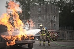 Latvian and Estonian firefighters train on a simulated car fire during Northern Strike 21-2 at the Alpena Combat Readiness Training Center, Michigan, Aug. 6, 2021. Northern Strike is an opportunity to build readiness and interoperability with other units and multinational partners while training in realistic multi-domain environments.