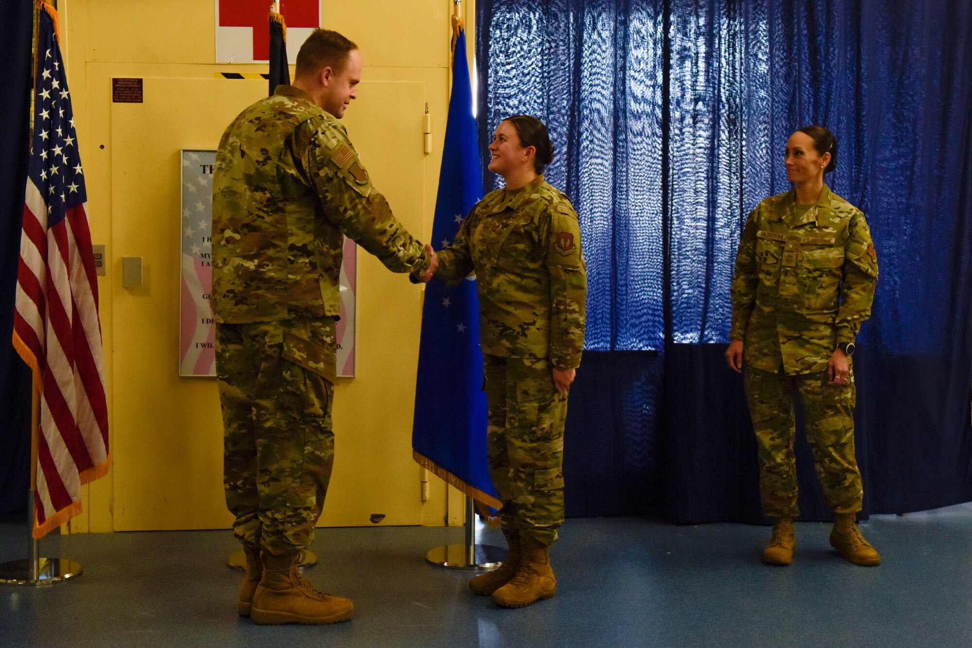 U.S. Air Force Col. Denny Davies shakes Senior Airman Audrey Allen's hand