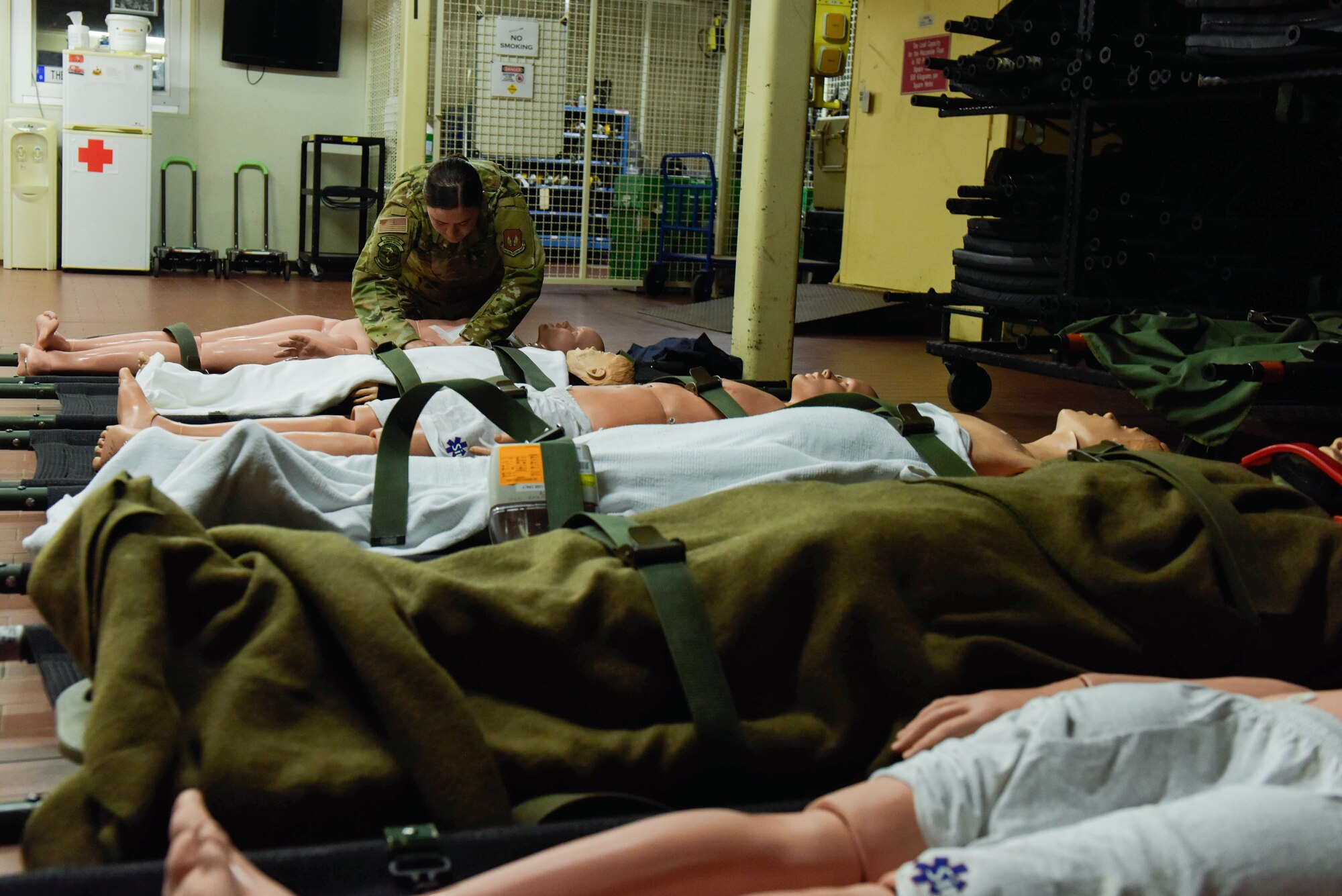 Senior Airman Audrey Allen applies a chest cover to a mannequin