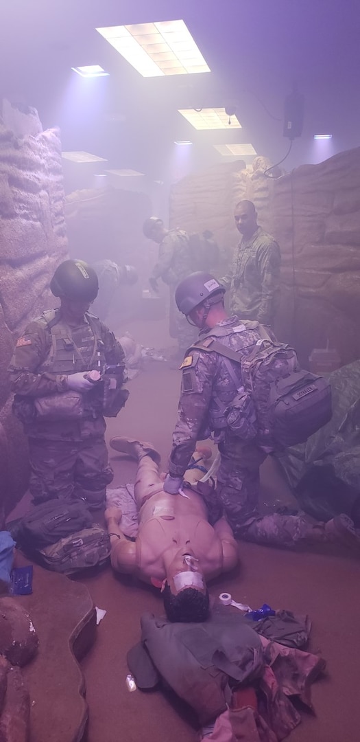 Combat medic trainees in the Medical Education and Training Campus Combat Medic Specialist Training Program treat a mock casualty in the Combat Trauma Patient Simulator.
