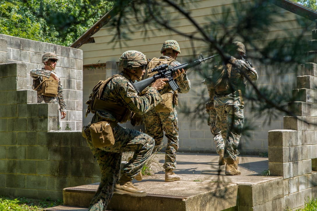 Marines with Alpha Company, Marine Barracks Washington, conduct military operations in urban terrain training at Marine Corps Base Quantico, Va., 11 July, 2021. The Marines learned, practiced, and implemented several different procedures: assaulting toward a building, clearing rooms and stairwells, and different techniques on navigating hallways and tight quarters. They finished the exercise with simulation ammunition and participated in notional squad versus squad engagements to better simulate a live urban environment. (U.S. Marine Corps photo by Lance Cpl. Allen Sanders)