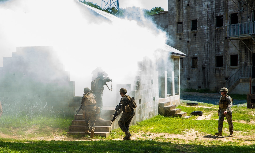 Marines with Alpha Company, Marine Barracks Washington, conduct military operations in urban terrain training at Marine Corps Base Quantico, Va., 11 July, 2021. The Marines learned, practiced, and implemented several different procedures: assaulting toward a building, clearing rooms and stairwells, and different techniques on navigating hallways and tight quarters. They finished the exercise with simulation ammunition and participated in notional squad versus squad engagements to better simulate a live urban environment. (U.S. Marine Corps photo by Lance Cpl. Allen Sanders)