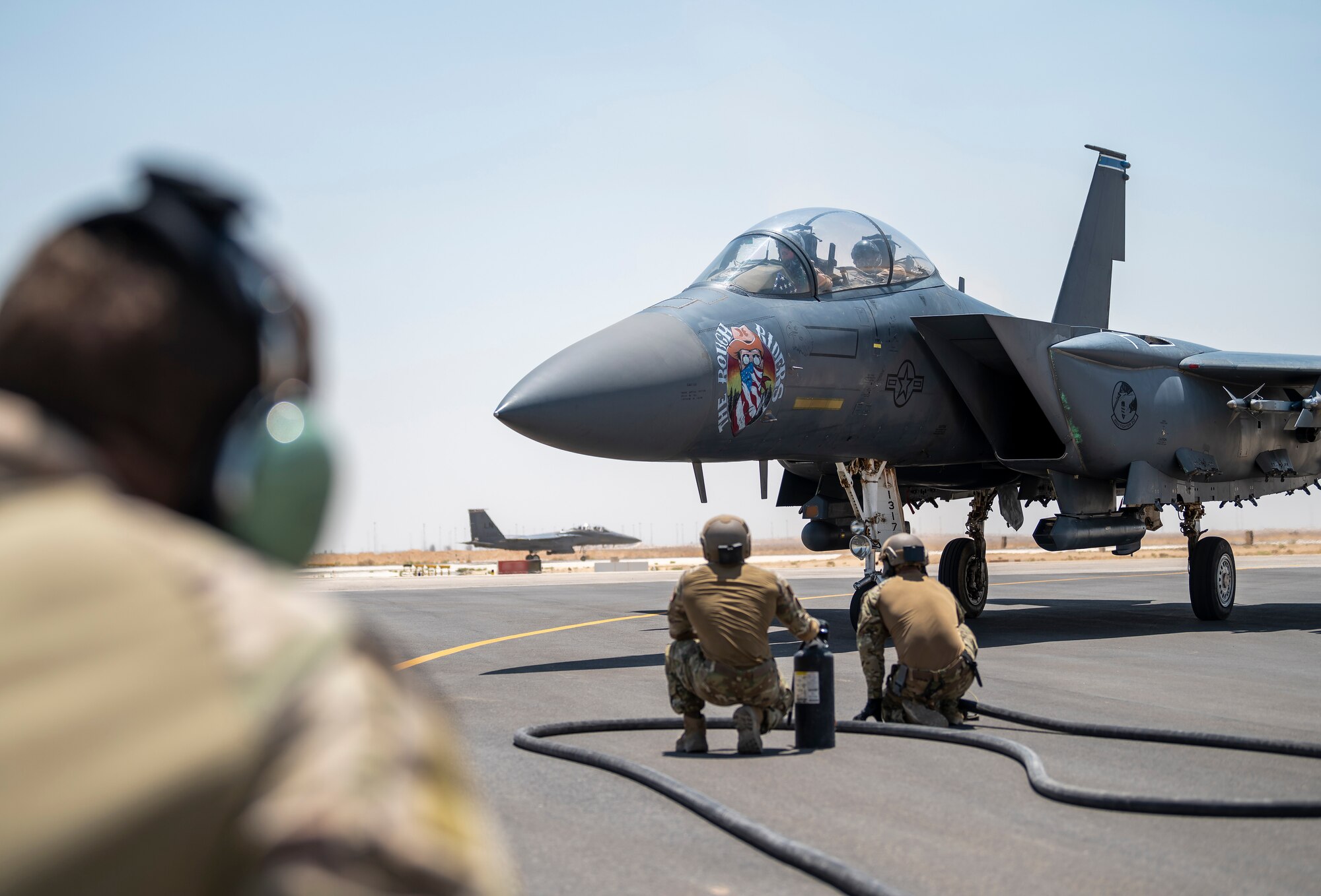 U.S. Airmen from the 26th Expeditionary Rescue Squadron participate in a Forward Area Refueling Point (FARP) exercise for two F-15E Strike Eagles August 2, 2021, at an undisclosed location somewhere in Southwest Asia. FARP training prepares Airmen to effectively refuel aircraft in austere locations when air-to-air refueling is not possible or when fueling stations are not accessible. (U.S. Air Force photo by Senior Airman Karla Parra) (This image is blurred for security reasons)