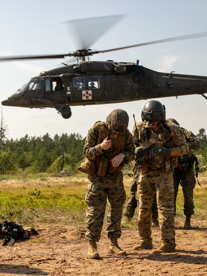 Marines with Combat Logistics Battalion (CLB) 451, 4th Marine Logistics Group, brace as casualty evacuation helicopters take off during a simulated attack during Northern Strike 21-2 at Camp Grayling, Michigan on Aug. 10, 2021. Northern Strike is an annual exercise hosted by the National Guard aboard the National All-Domain Warfighting Center at Camp Grayling, MI. Reserve Marines with CLB 451 are providing direct and general support to Joint Task Force 85, increasing interoperability with sister services. (U.S. Marine Corps photo by Lance Cpl. Colby Bundy)