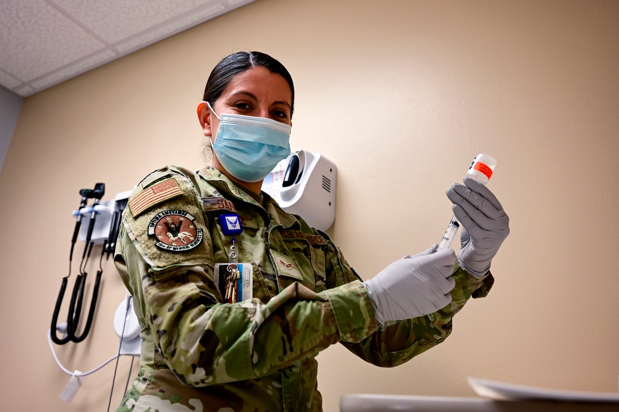 An Airman holds a vial in a medical facility.