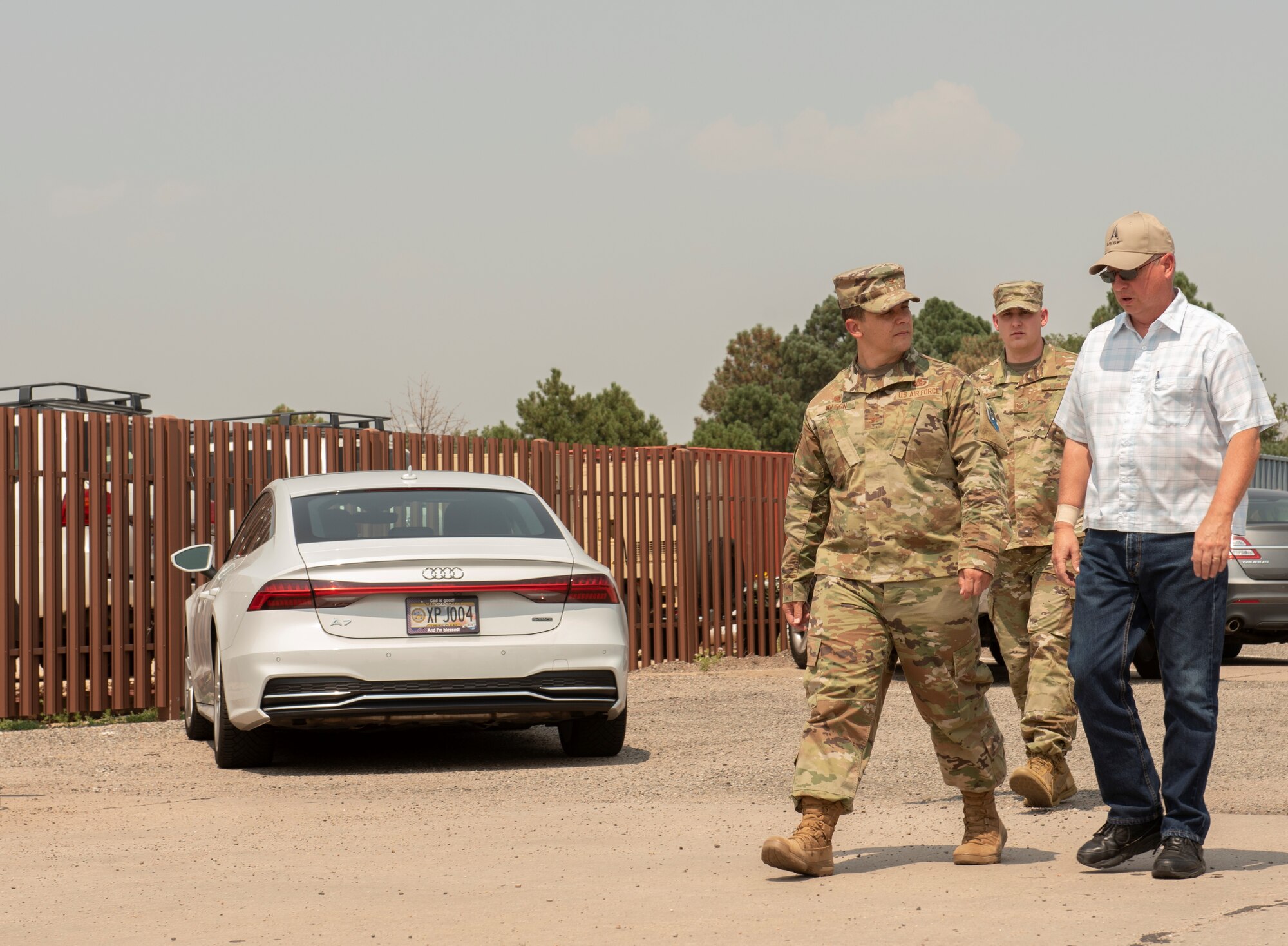 Col. Wilson and 2 other individuals walk towards a prospective job site.