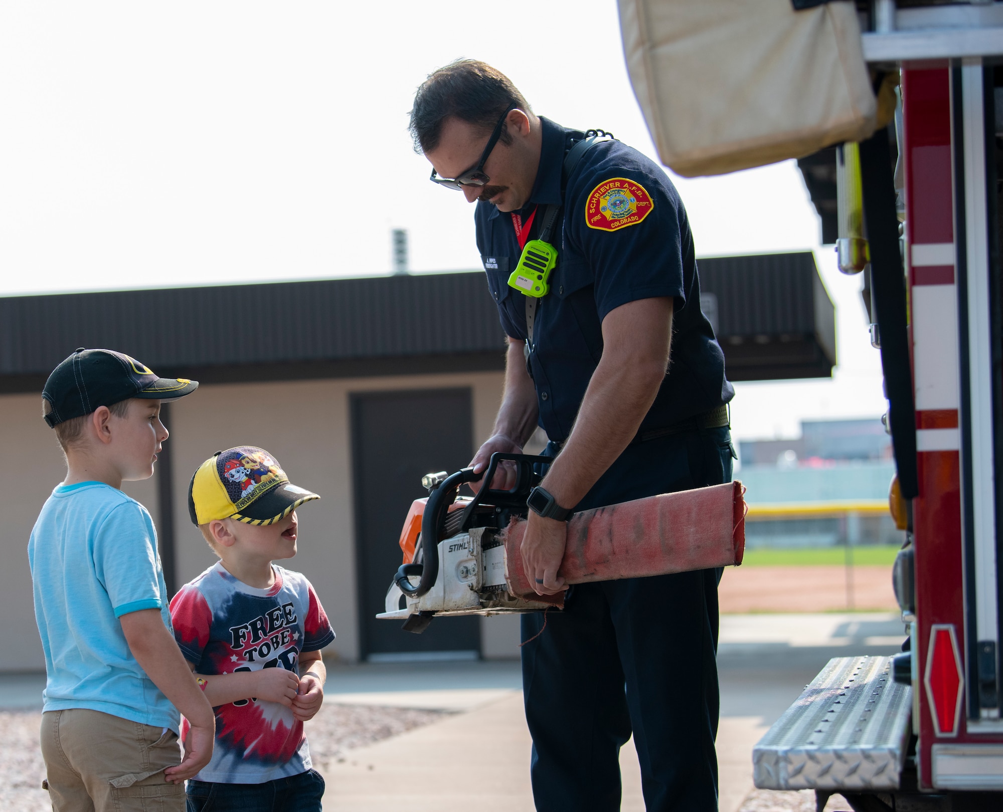 Firefighter show chainsaw to kids