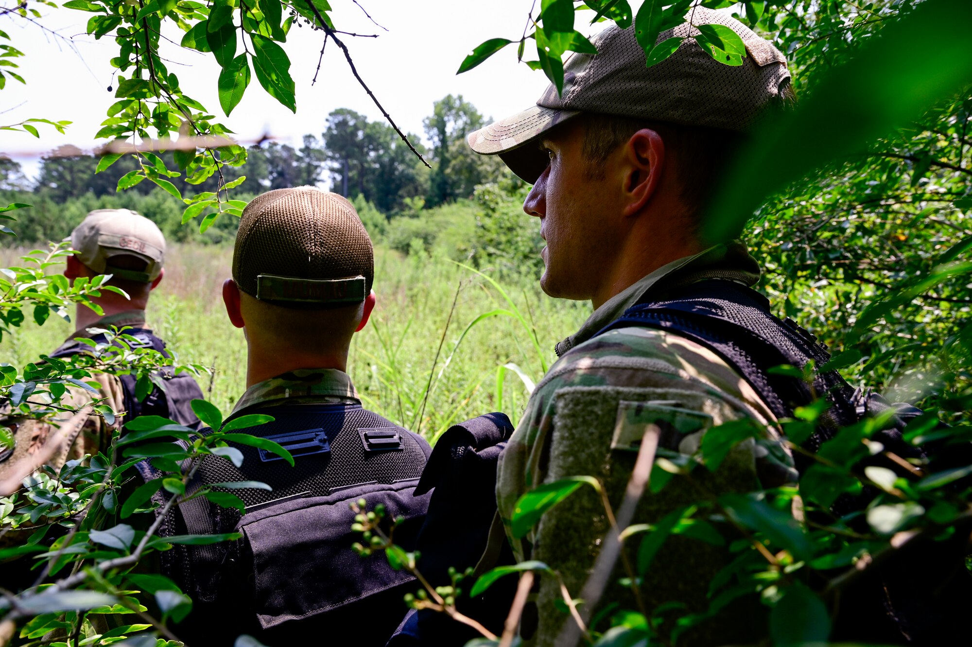 Airmen navigate the woods during training.
