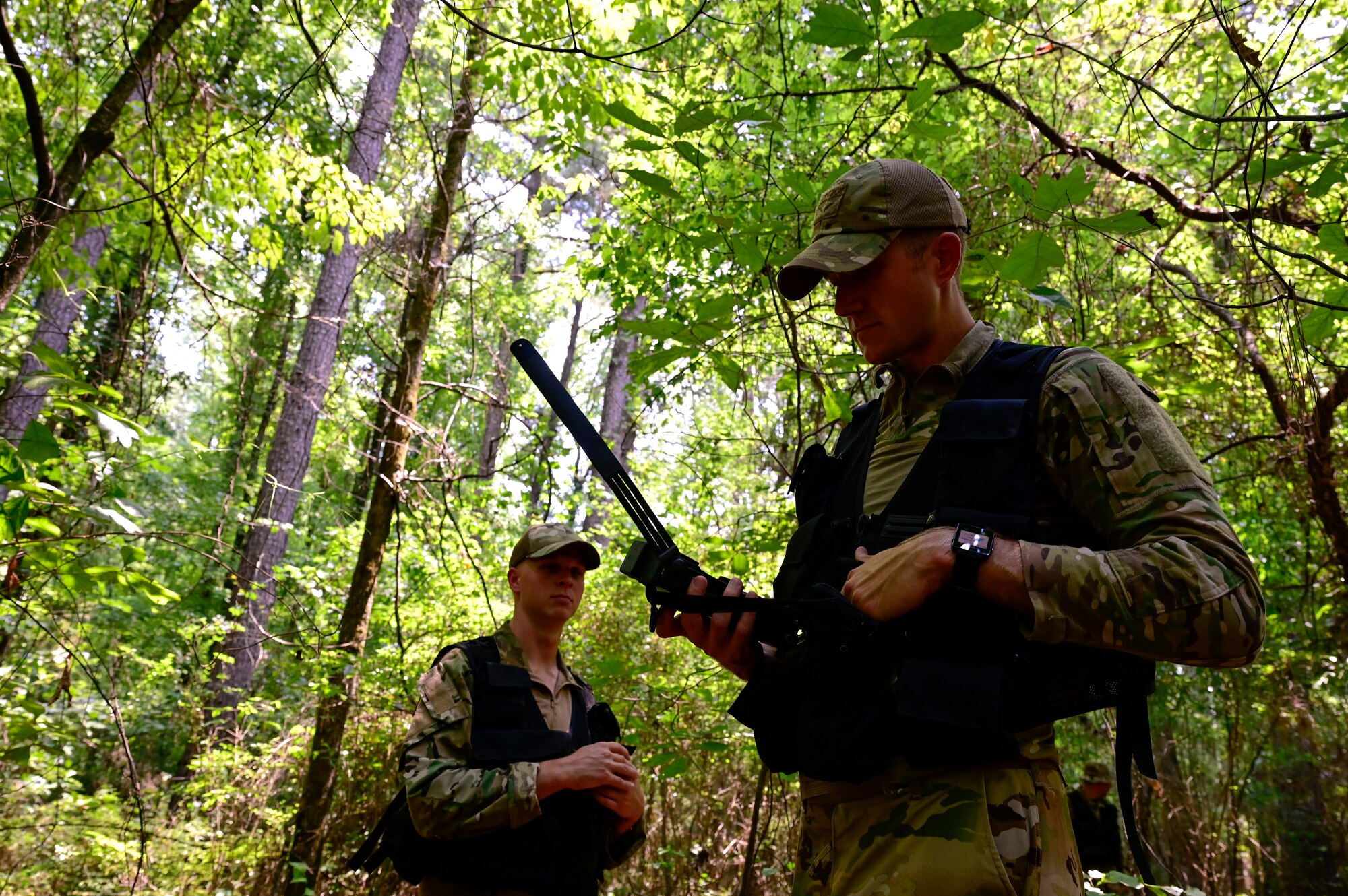Two Airman go through training in the woods.