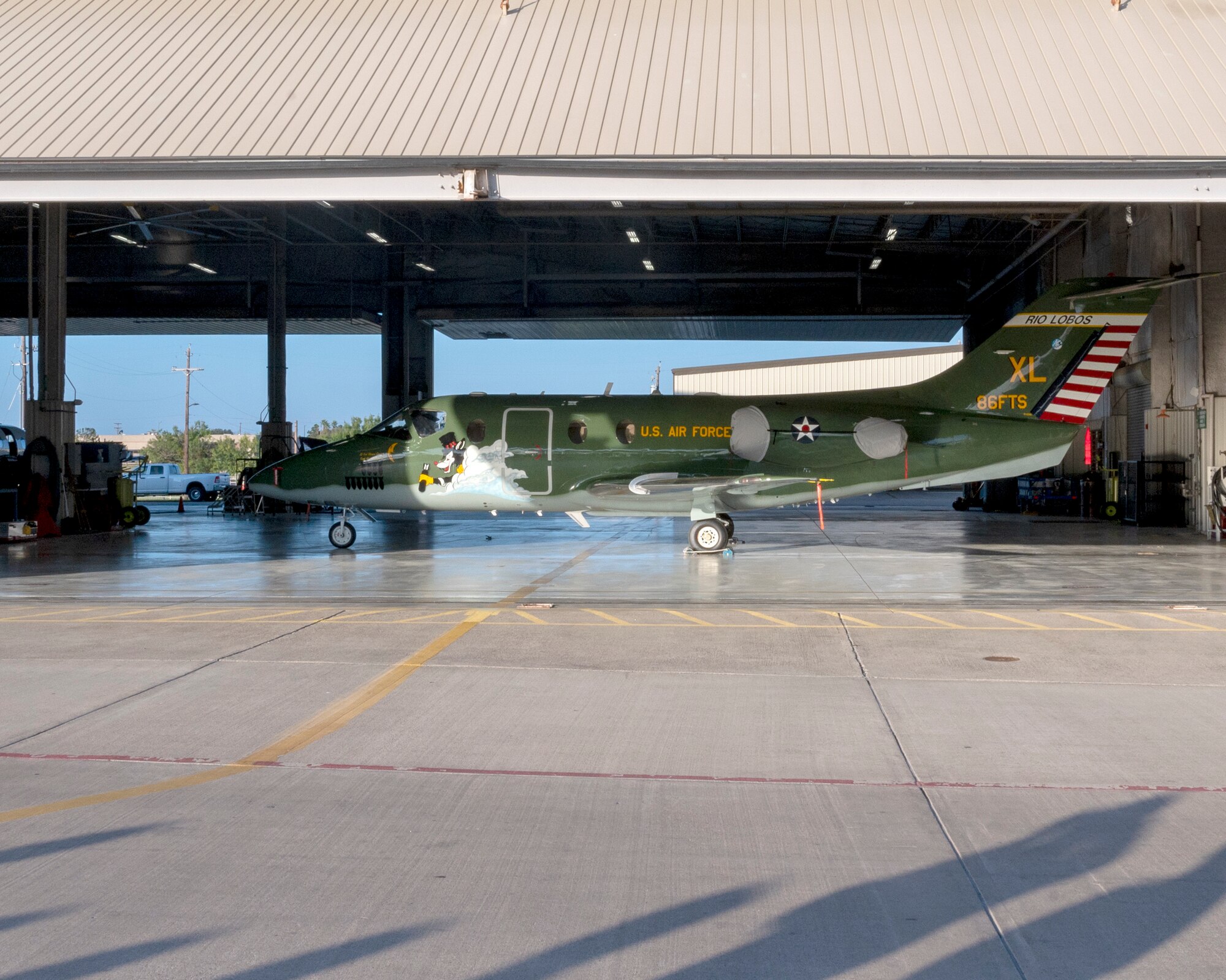 The new heritage tail of the 86th Flying Training Squadron is unveiled as the hangar door lifts up on August 13, 2021 at Laughlin Air Force Base, Texas. The paint scheme of the aircraft reflects a heritage that dates back to the Douglas B-18 “Bolo” of World War II.(U.S. Air Force Photo by Senior Airman Nicholas Larsen)