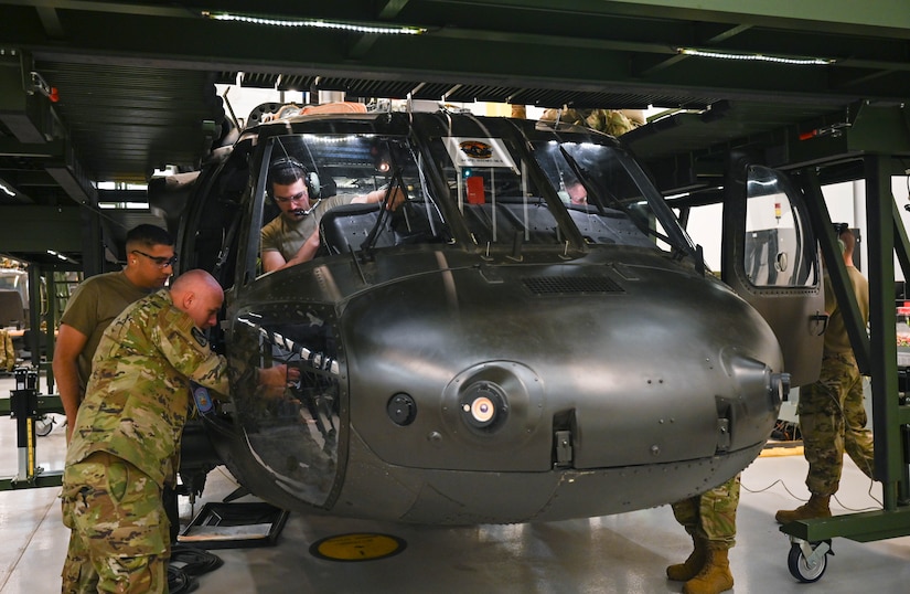 U.S. Air Force Airmen, assigned to the 362nd Training Squadron, Detachment One, conduct helicopter maintenance on a Sikorsky UH-60 Black Hawk helicopter, simulator at Joint Base Langley-Eustis, Virginia, July 16, 2021. The training course is designed to encourage students to work and communicate with each other to master these tasks. (U.S. Air Force photo by Senior Airman Sarah Dowe)