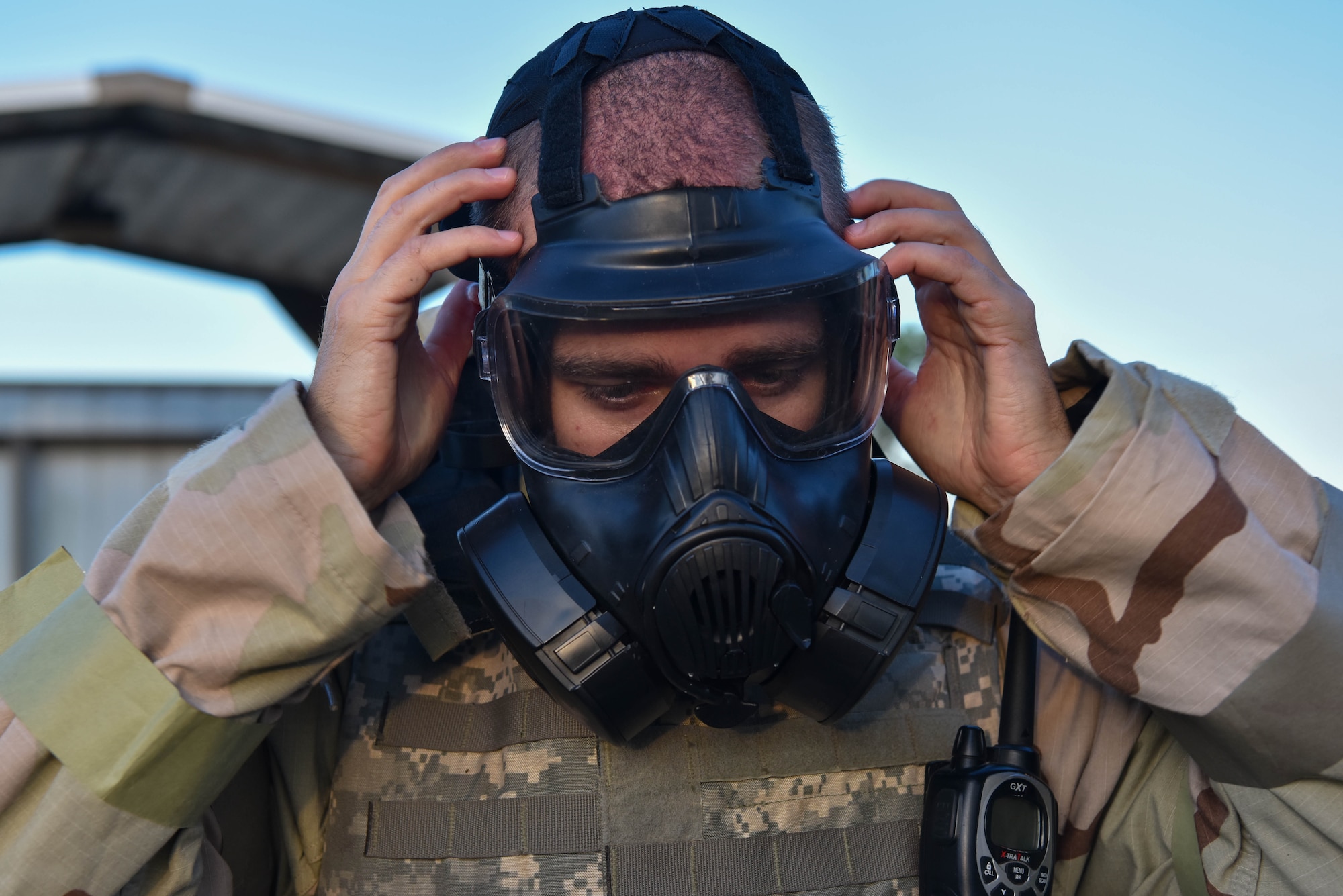 U.S. Air Force Tech. Sgt. Mike Lowry, 315th Training Squadron instructor, dons a gas mask during the Expeditionary Readiness Training exercise on Goodfellow Air Force Base, Aug. 13, 2021. Throughout the week, Airmen were trained on the fundamentals of chemical, biological, radiological and nuclear defense, combat arms proficiency, self-aid buddy care, and the Law of Armed Conflict. (U.S. Air Force photo by Senior Airman Jermaine Ayers)