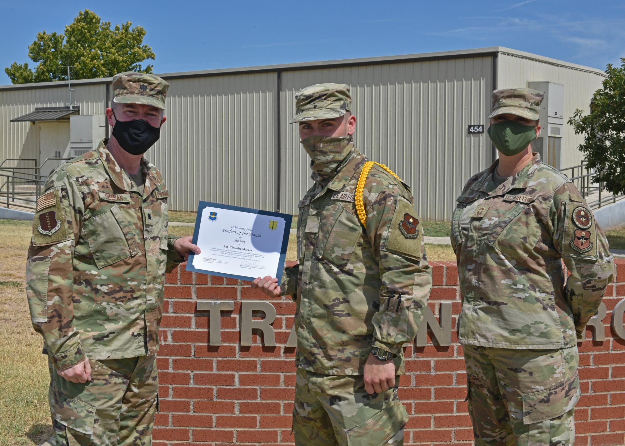 U.S. Air Force Lt. Col. James Freeman, 17th Training Group deputy commander, and Senior Master Sgt. Heather Celano, 313th Training Squadron superintendent, present Airman 1st Class Timothy Maker, 312th Training Squadron student, the 17th TRG Student of the Month award for July 2021, on Goodfellow Air Force Base, Texas, August 13, 2021. The 312th TRS is responsible for training joint service members on special instruments and fire emergency services. (U.S. Air Force photo by Senior Airman Ashley Thrash)