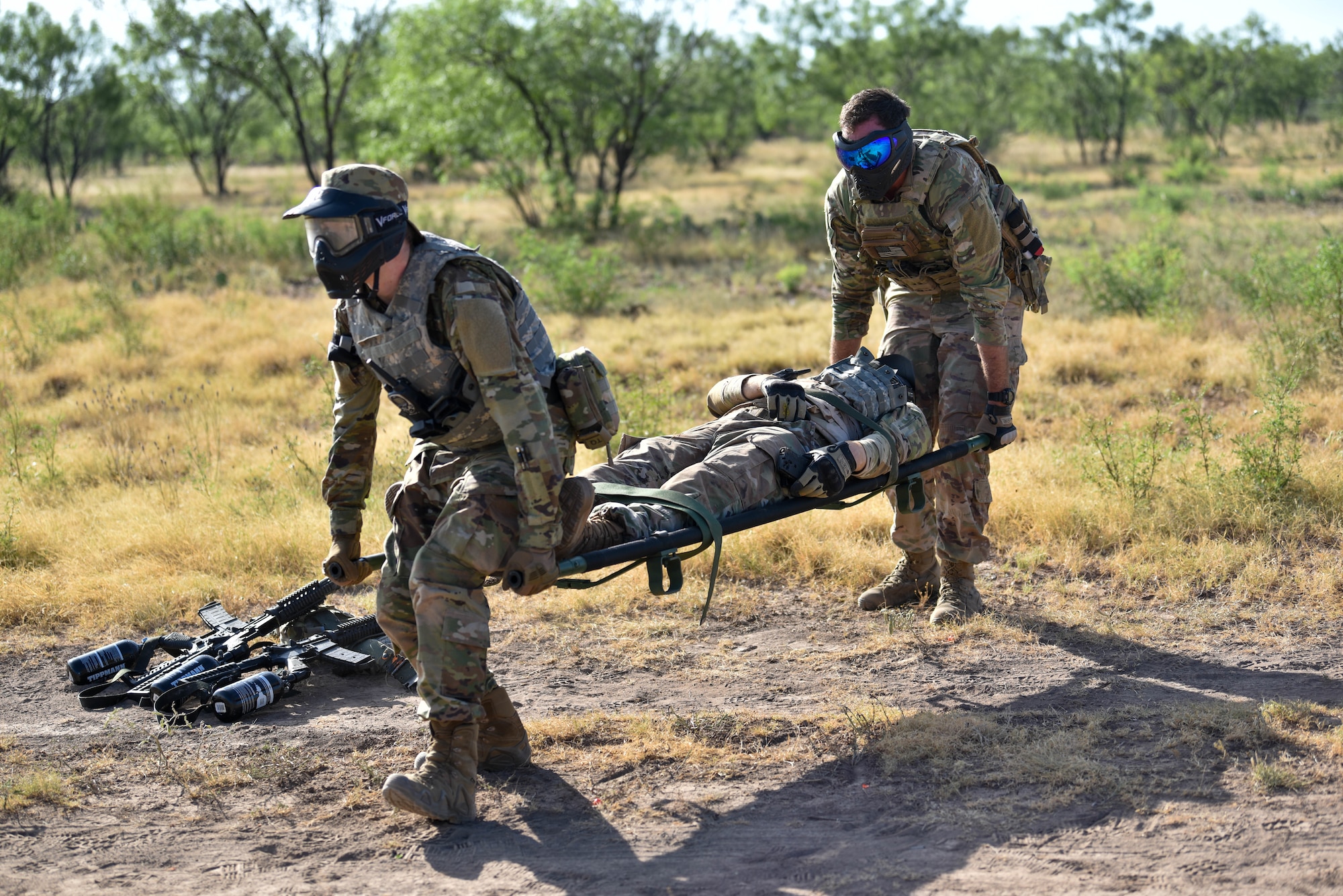 U.S. Air Force Airman 1st Class Drizzt Cox, 17th Training Support Squadron network technician, and Maj. Joseph Newman, 17th Logistics Readiness Squadron commander, perform a two-man gurney carry during the Expeditionary Readiness Training on Goodfellow Air Force Base, Aug. 13, 2021. Airmen were trained on the fundamentals of self-aid buddy care and a variety of combated-related wounds. (U.S. Air Force photo by Senior Airman Jermaine Ayers)