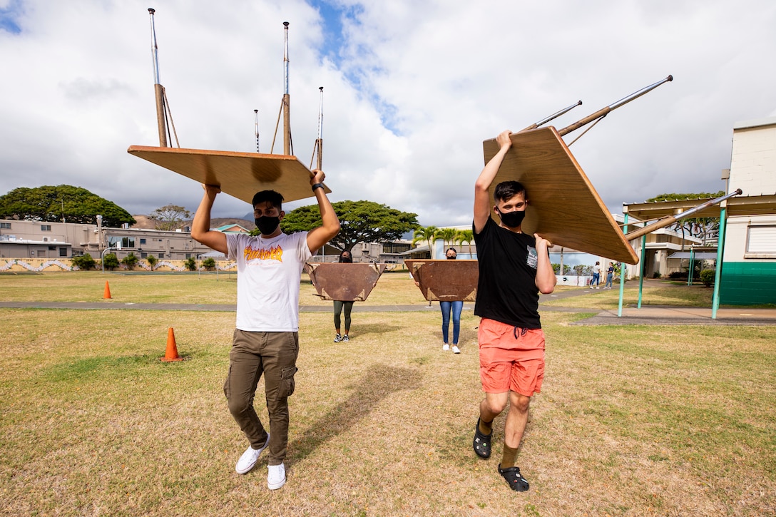 U.S. Marines with Headquarters Battalion, Marine Corps Base Hawaii, carry desks to another classroom during a volunteer event at Kailua Elementary School, Hawaii, July 30, 2021. MCBH’s most important resource is people, partnering with and supporting the local community is among the installation’s top priorities. (U.S. Marine Corps photo by Lance Cpl. Samantha Sanchez)