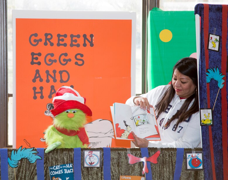 Vanessa Tzorin-Stacy reads a book to children while Reece Dilingham operates the puppet during a puppet show read-along at the base Library, McTureous Hall, aboard Marine Corps Logistics Base Barstow, California, March 4, 2019