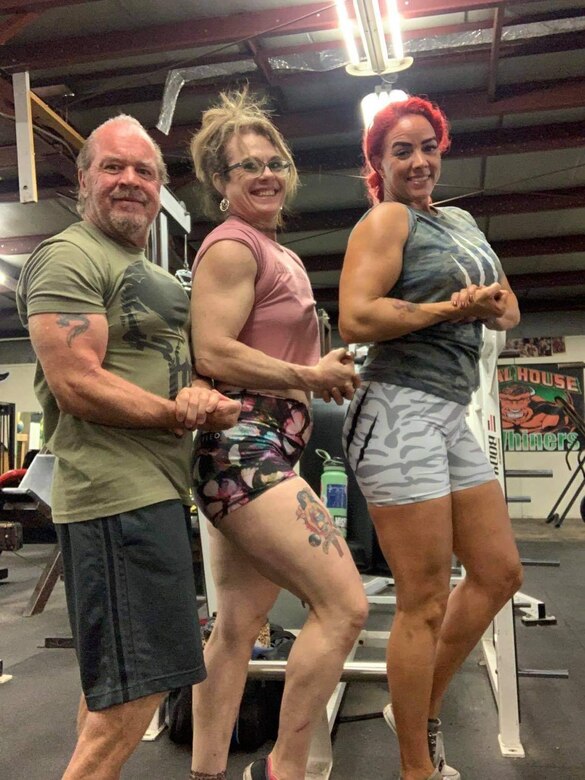 James Seifert, Brooke Verrill and Michelle Lawing show off their “guns” after a workout at Animal House Gym, Barstow, California, July 23. The two ladies are coached by James Seifert, Giant Killer Fitness, and recently broke personal records at the Rise of the Valkyrie, all-women’s powerlifting meet hosted by Iron Monger’s Gym in Vista, California and are headed to the World Championships! (Photo courtesy of James Seifert)