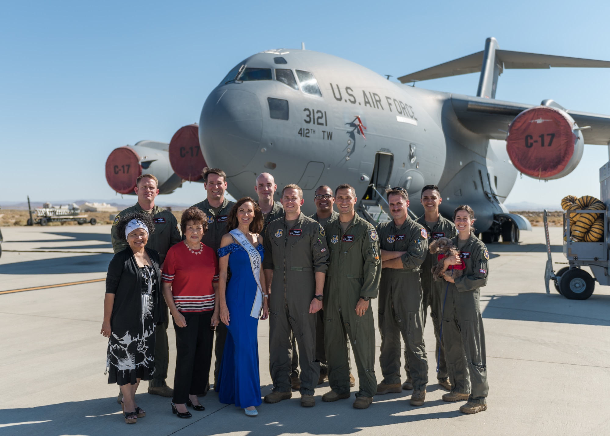 The reigning Mrs. California Universe, Lynelle DeRoo-Marcos, the wife of Perry Marcos, a Standards/Evaluation and training technician with the 418th Flight Test Squadron, poses for a photo with members of the 418th FLTS during her visit to the squadron at Edwards Air Force Base, California, Aug. 2. (Air Force photo by Bryce Bennett)