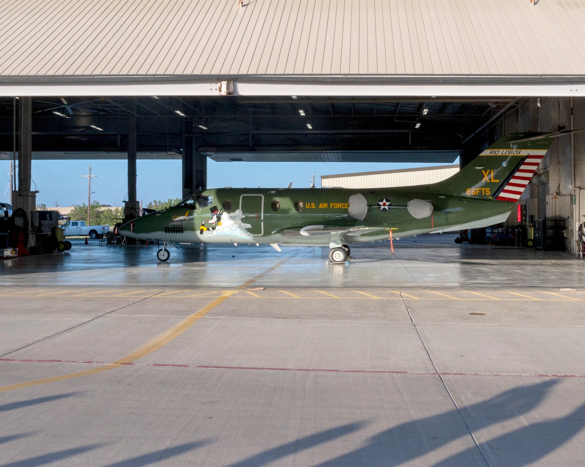 The new heritage tail of the 86th Flying Training Squadron is unveiled as the hangar door lifts up on August 13, 2021 at Laughlin Air Force Base, Texas. The paint scheme of the aircraft reflects a heritage that dates back to the Douglas B-18 “Bolo” of World War II.(U.S. Air Force Photo by Senior Airman Nicholas Larsen)