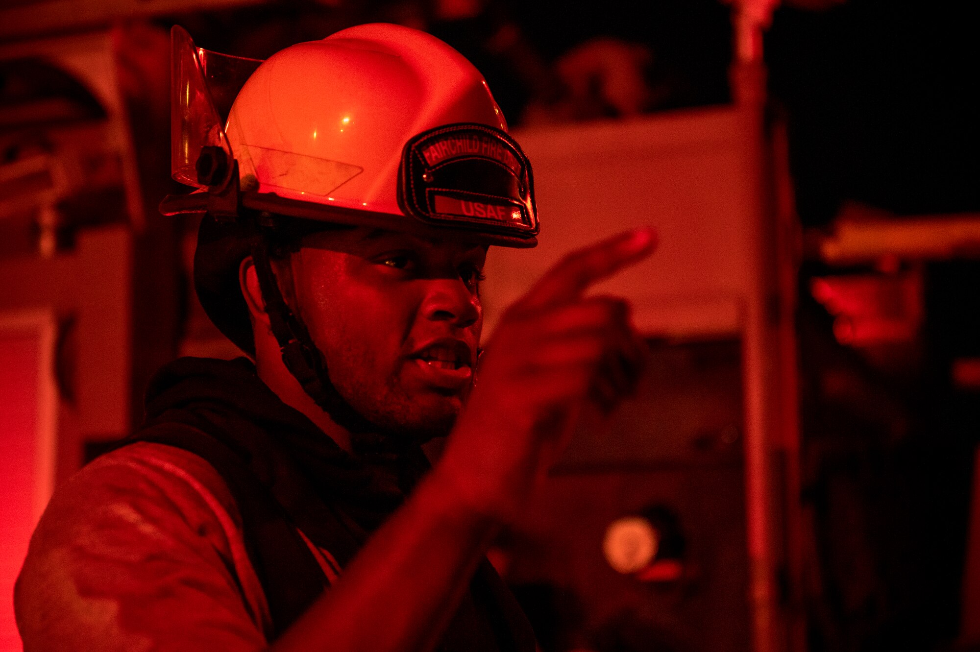 Airman 1st Class Ian Edward, 379th Expeditionary Civil Engineer Squadron firefighter, directs a fellow firefighter during a live-fire training exercise August 10, 2021, at Al Udeid Air Base, Qatar.