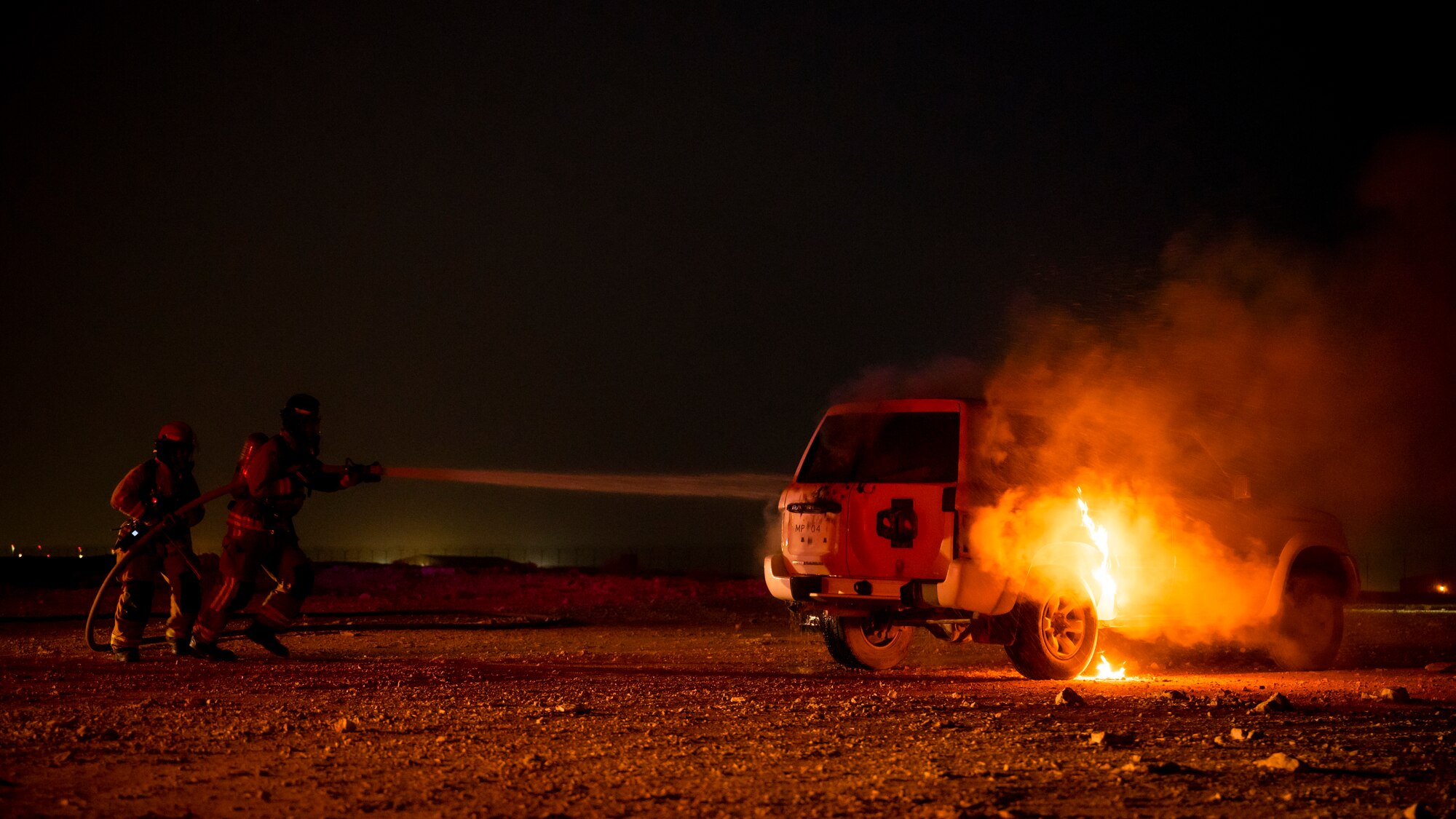 379th Expeditionary Civil Engineer Squadron firefighters extinguish a car fire during a training exercise August 10, 2021, at Al Udeid Air Base, Qatar.