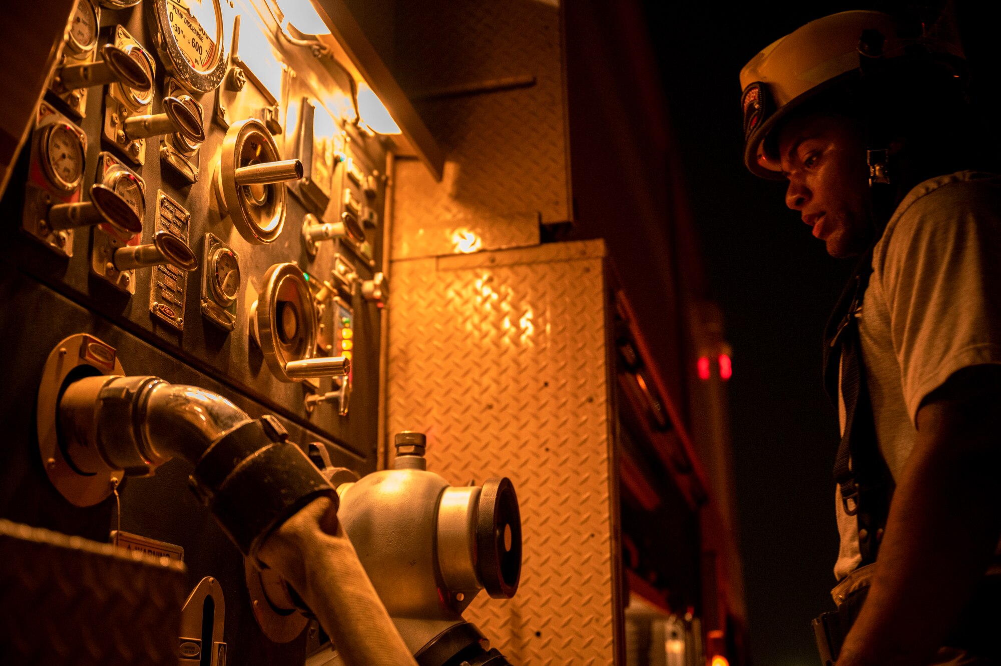 Airman 1st Class Ian Edward, 379th Expeditionary Civil Engineer Squadron firefighter, checks equipment during a live-fire training exercise August 10, 2021, at Al Udeid Air Base, Qatar.