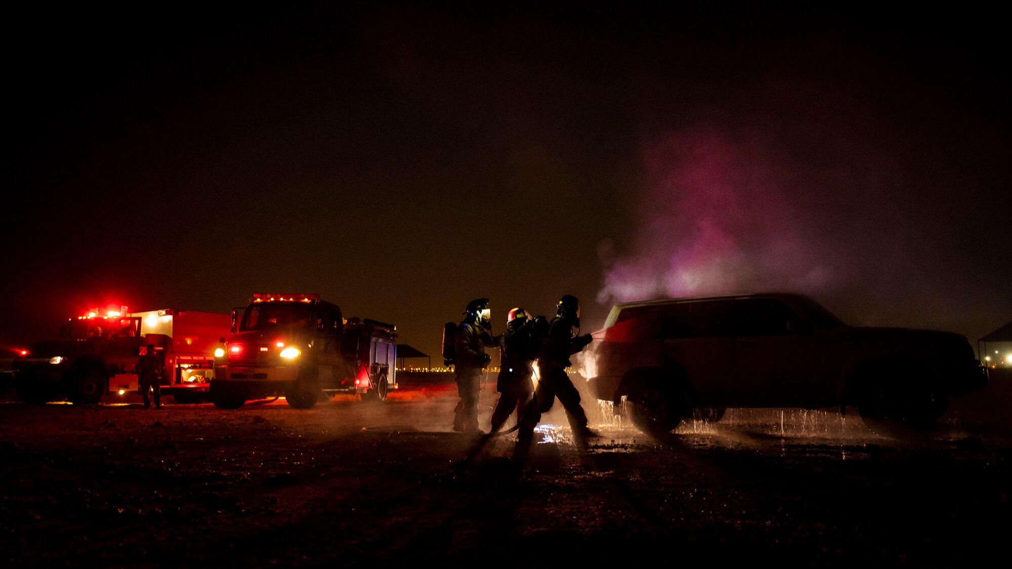 379th Expeditionary Civil Engineer Squadron firefighters extinguish a car fire during a training exercise August 10, 2021, at Al Udeid Air Base, Qatar.