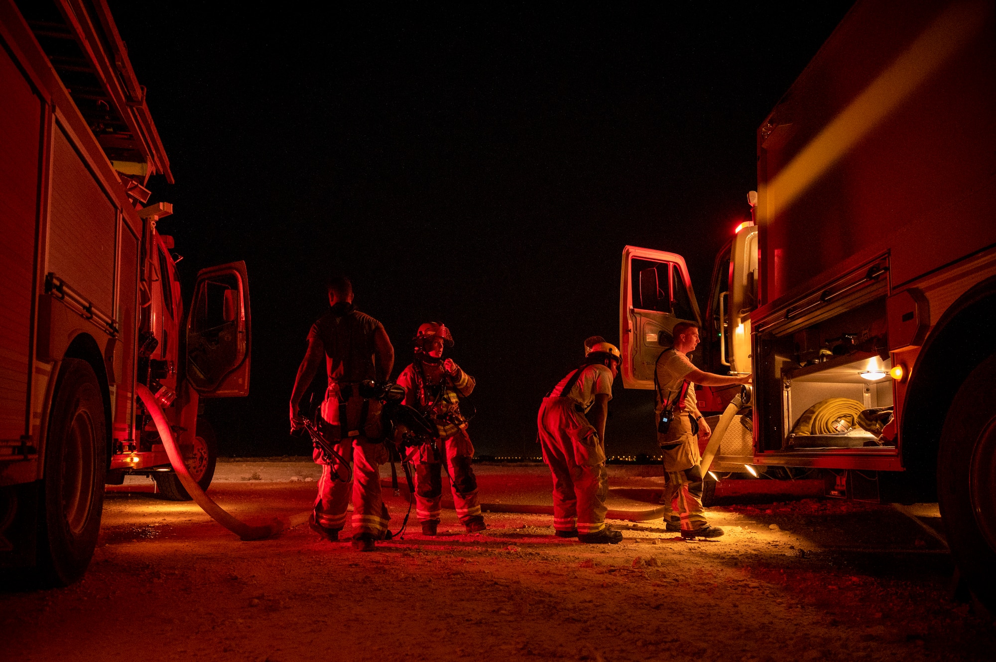 379th Expeditionary Civil Engineer Squadron firefighters put away gear and check equipment following a live-fire training August 10, 2021, at Al Udeid Air Base, Qatar.