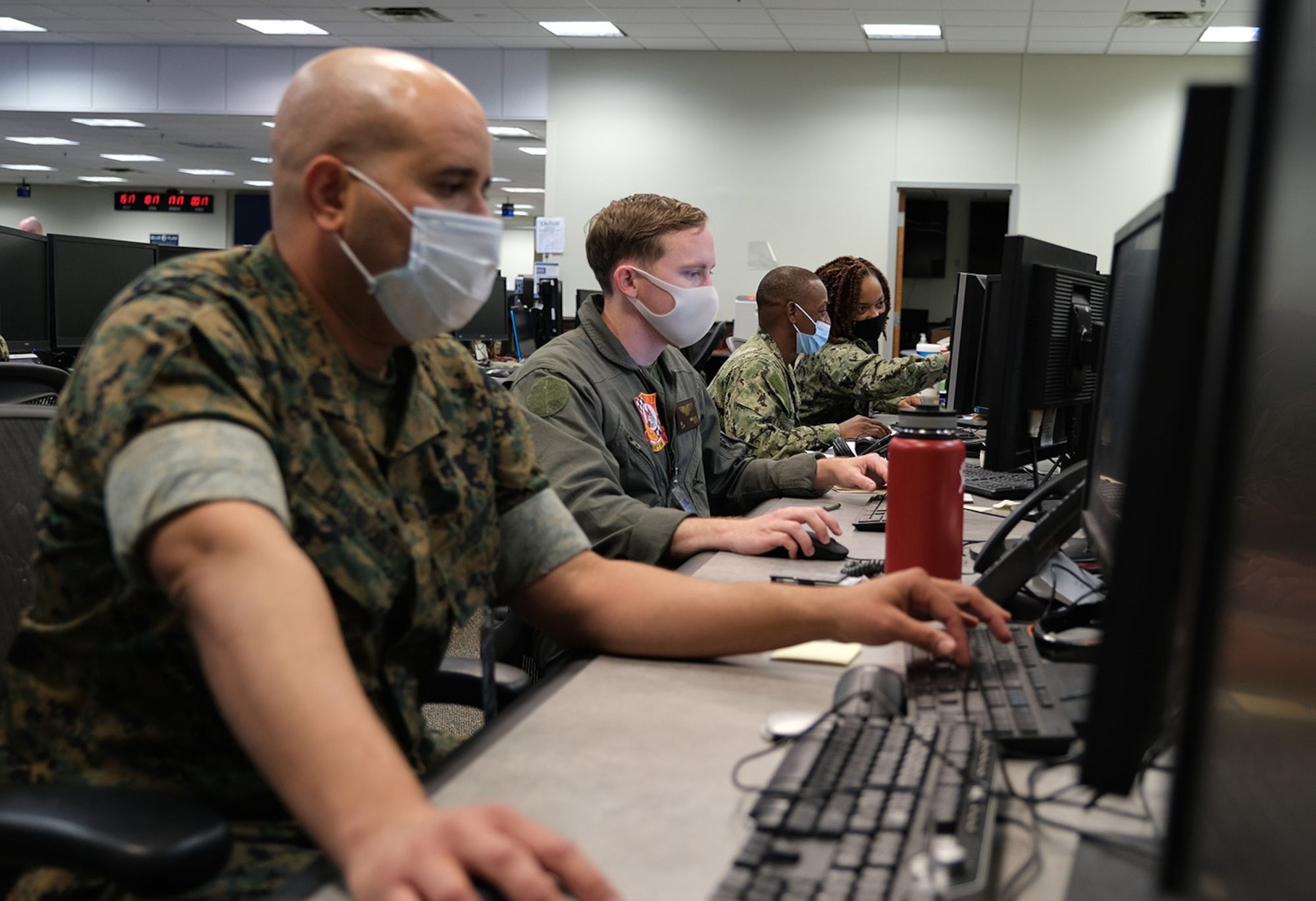 Photo of U.S. Service men and women sitting at computers