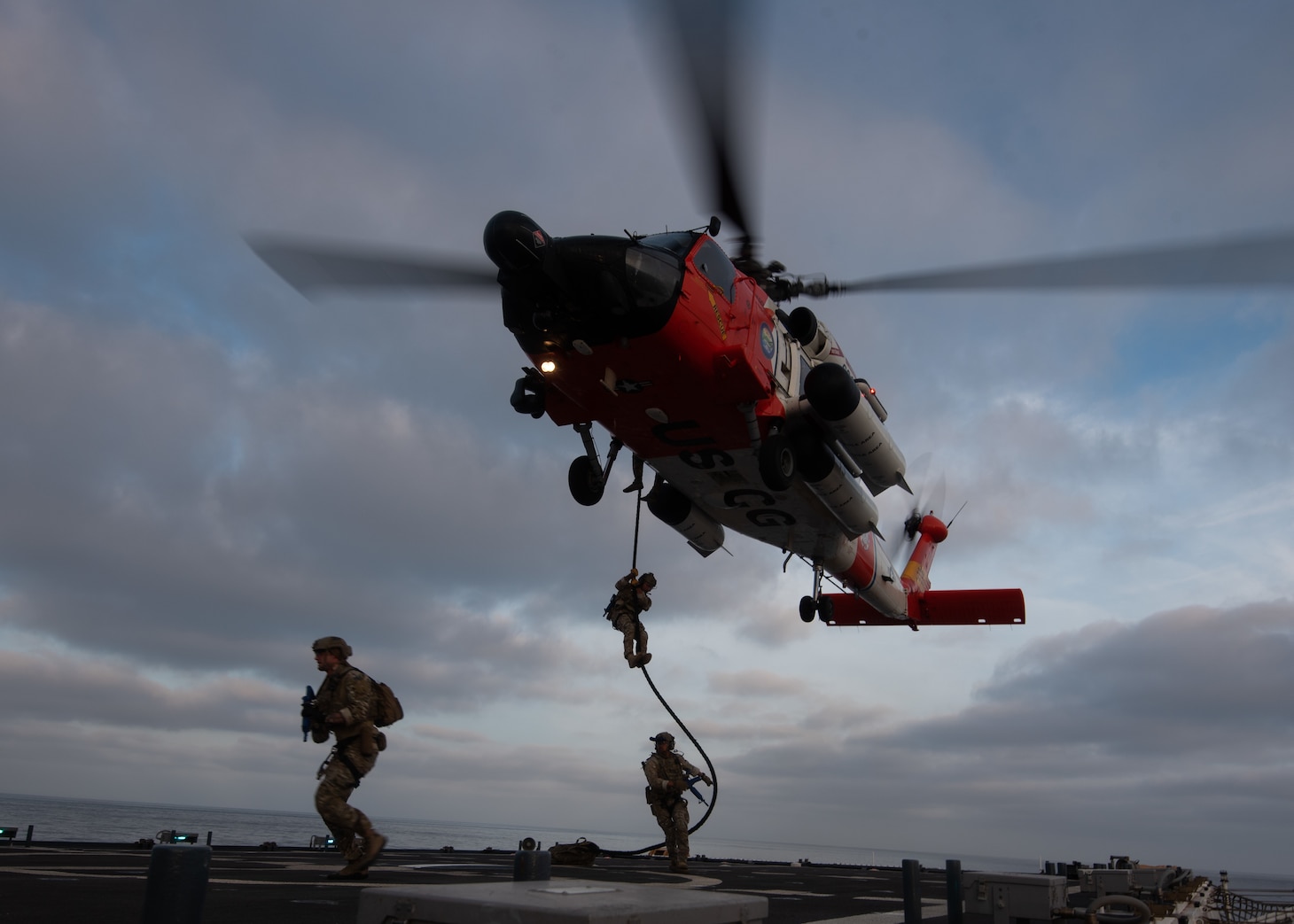 Coast Guard Maritime Security Response Team-West members fast-rope of an MH-60J Jayhawk onto the Coast Guard Cutter Munro during flight operations off the coast of San Diego, California, July 23, 2021. The Coast Guard Cutter Munro conducted flight operation training with the U.S. Navy and Maritime Security Response Team-West to maintain operational proficiencies.