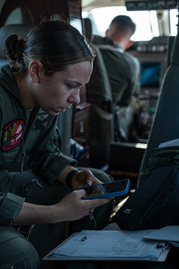 岩国基地で7月19日、厚木米海軍航空施設への旅客輸送任務のフライトで重量チャートを計算する海兵輸送中隊岩国分遣隊の航空輸送乗務員、テイラー・アルモンド伍長。（写真：ミッチェル・オースティン伍長）