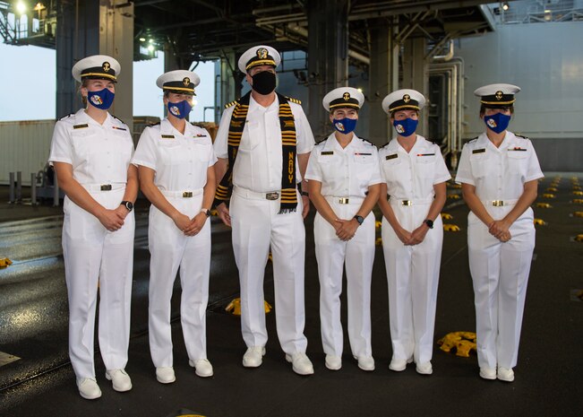 Capt. Chad Graham, commanding officer of the Expeditionary Sea Base Hershel "Woody" Williams (ESB 4), third from left, poses with midshipmen from the United States Naval Academy following a tour of the ship, Aug. 13, 2021.