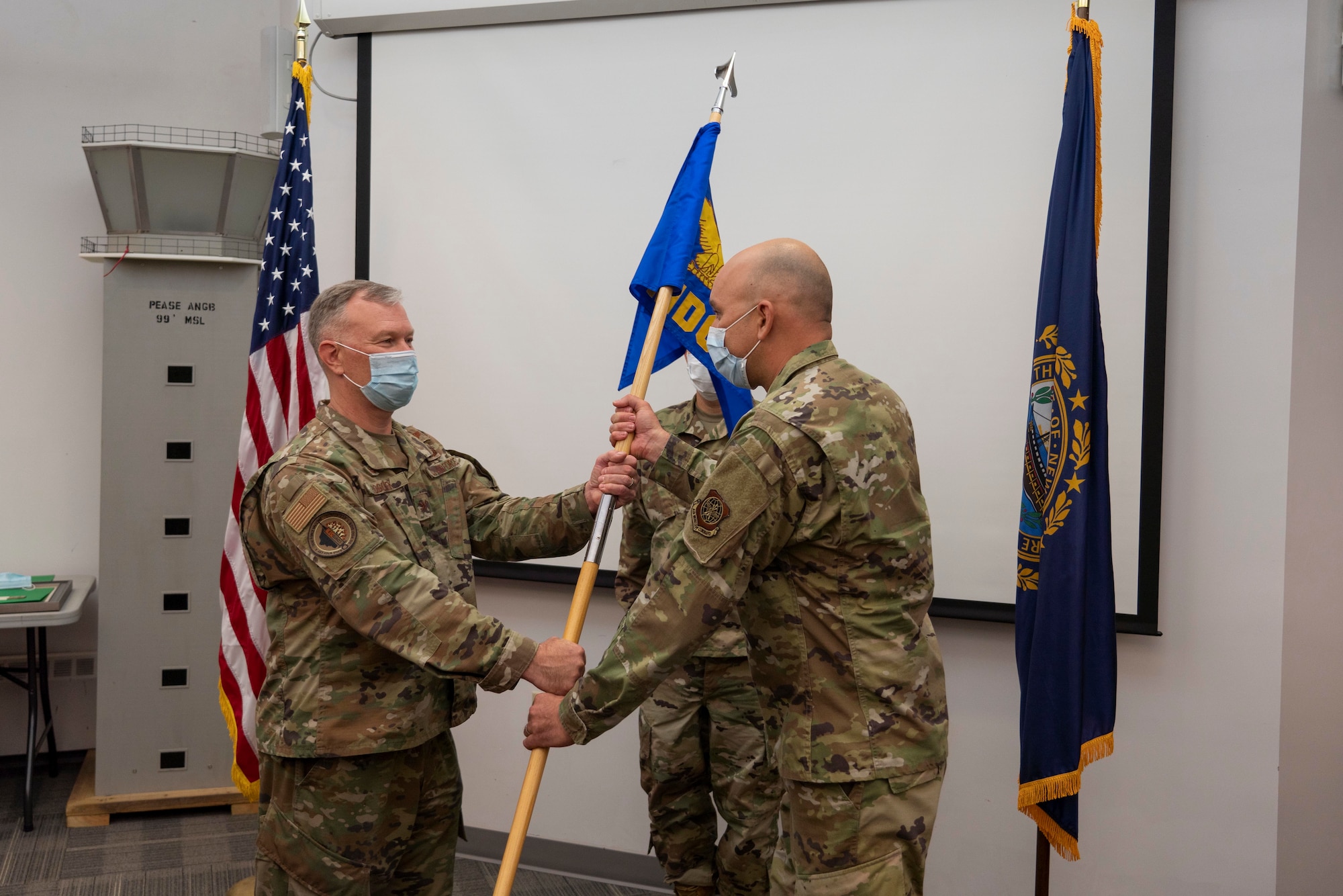 Col. John Pogorek, 157th Air Refueling Wing commander, presents the 157th Medical Group guidon to the group’s new commander, Lt. Col James Brown, during an assumption of command ceremony at Pease Air National Guard Base, Aug. 14, 2021. (U.S. Air National Guard photo by Staff Sgt. Taylor Queen)