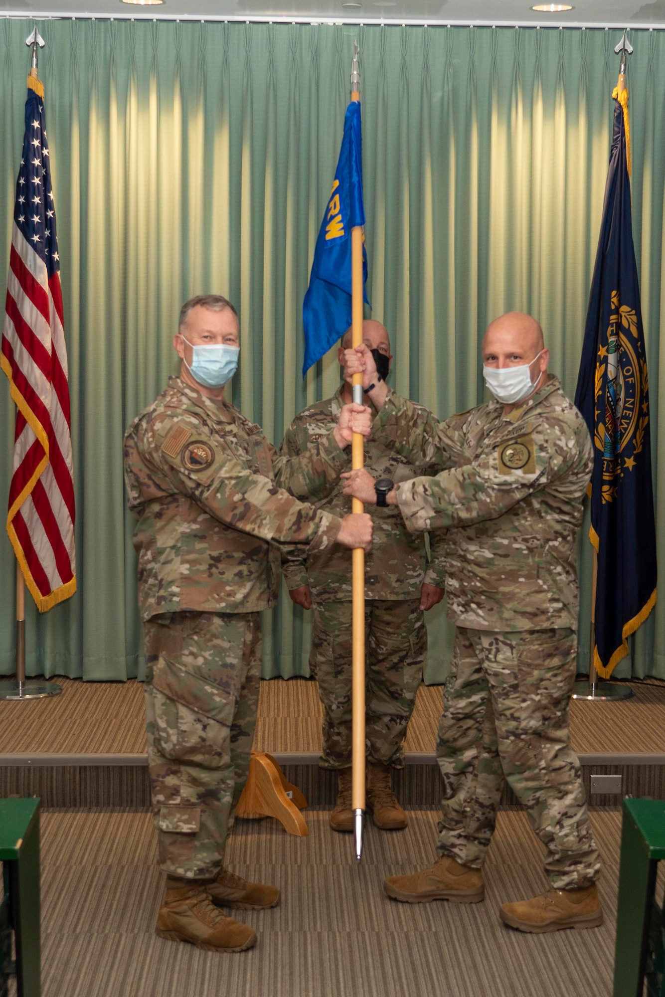 Col. John Pogorek, 157th Air Refueling Wing commander, presents the 157th Mission Support Group guidon to the group’s new commander, Col. Anthony Pasquale, during an assumption of command ceremony at Pease Air National Guard Base, Aug. 14, 2021. (U.S. Air National Guard photo by Staff Sgt. Taylor Queen)