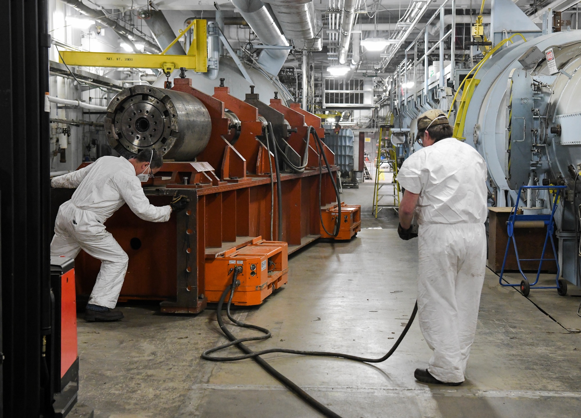 Tim Gilliam, left, Arnold Engineering Development Complex machinist, and Mark Carson, an AEDC lead machinist, move a 3.3-inch barrel section in the Hyper-ballistic Range G Feb. 23, 2021, at Arnold Air Force Base, Tenn. The section is being swapped out with an 8-inch barrel for a test. (U.S. Air Force photo by Jill Pickett)